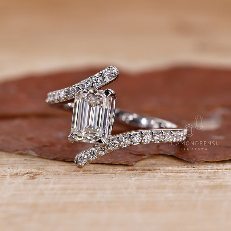 Buy engagement ring online with emerald cut and bypass style.
