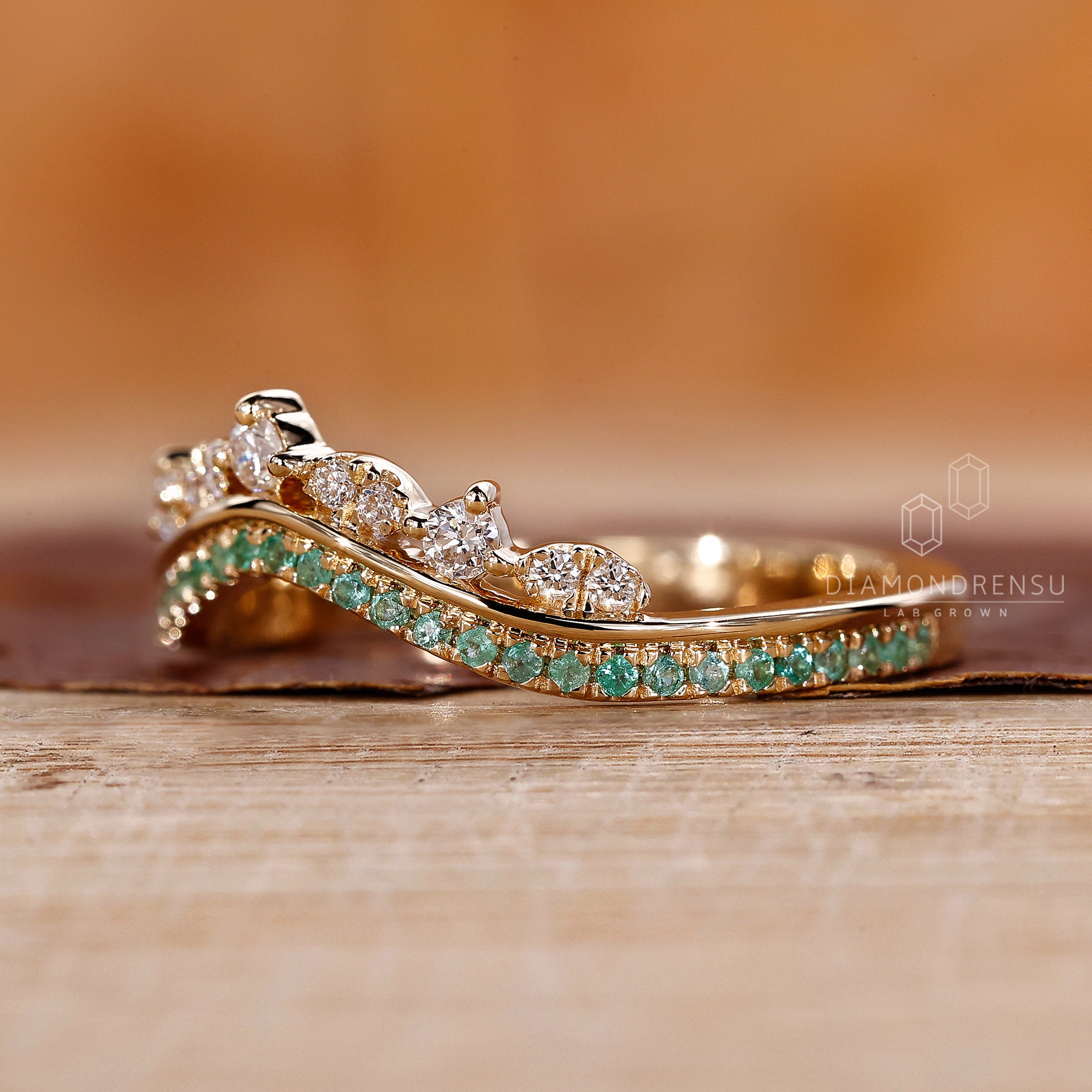 Round cut emerald and diamond wedding band.
