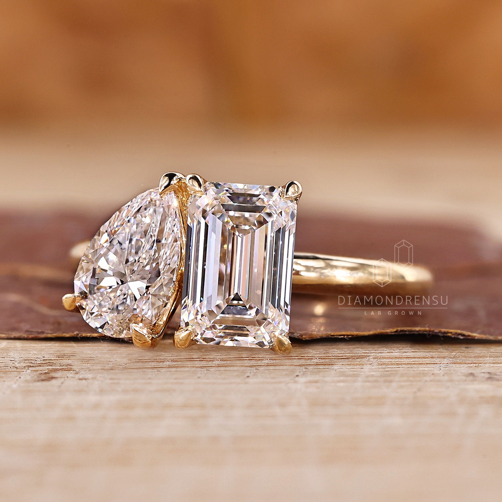 Solitaire style two stone ring with emerald and pear cuts