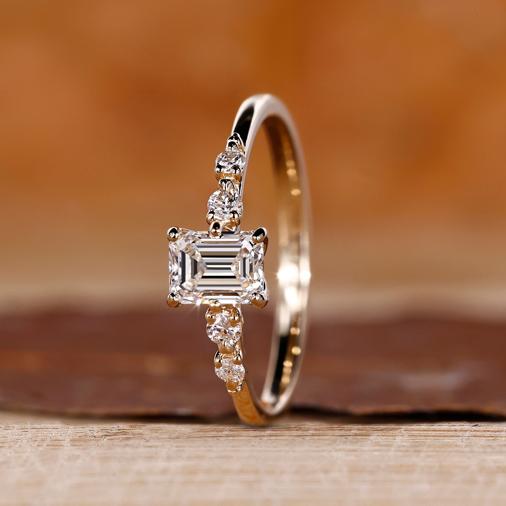 Emerald cut gold ring with round side stones.
