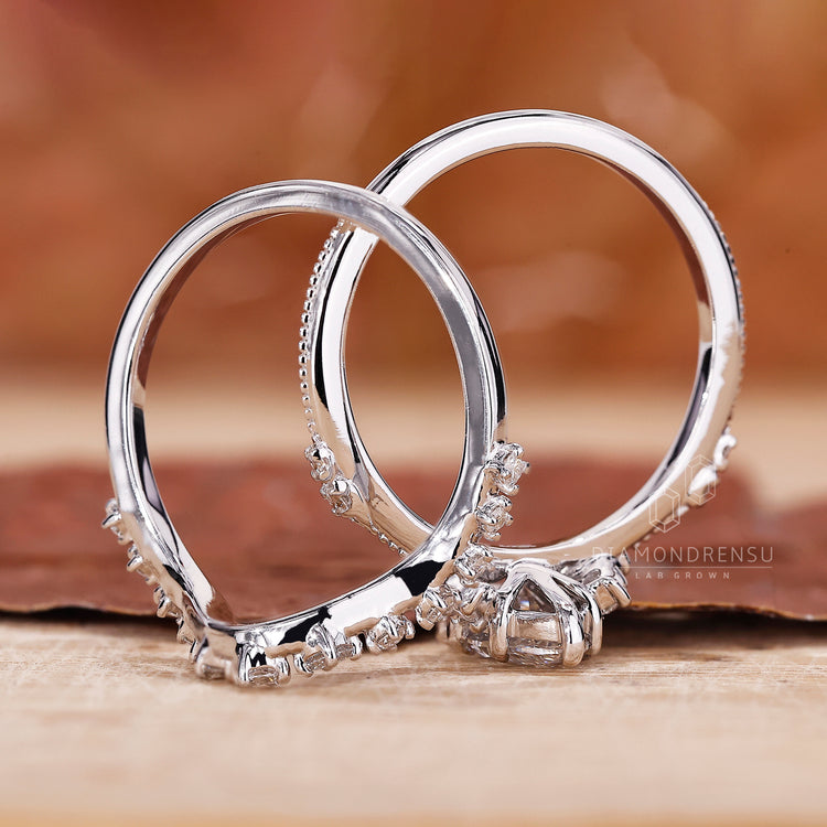 Round side stone paired with marquise engagement ring with wedding band.
