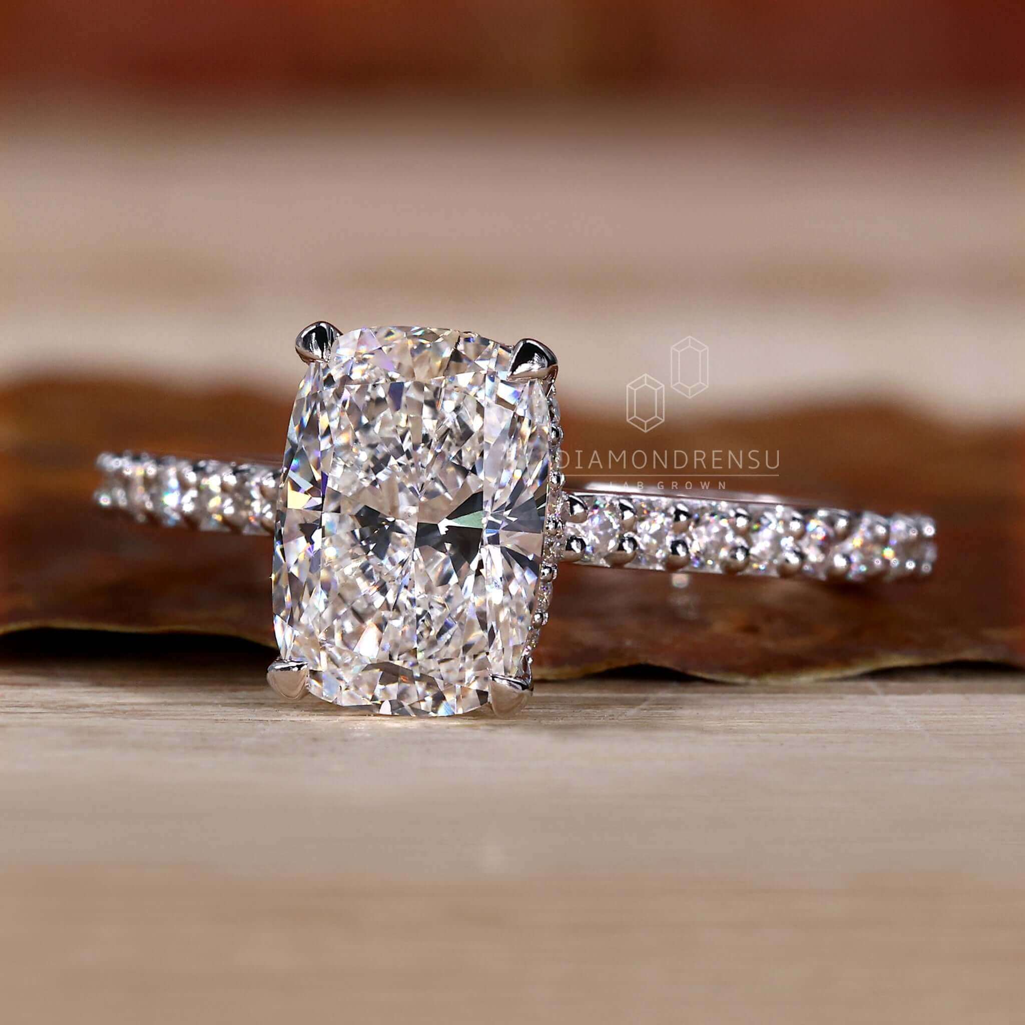 Pave diamond ring paired with a cushion cut engagement ring for timeless beauty.