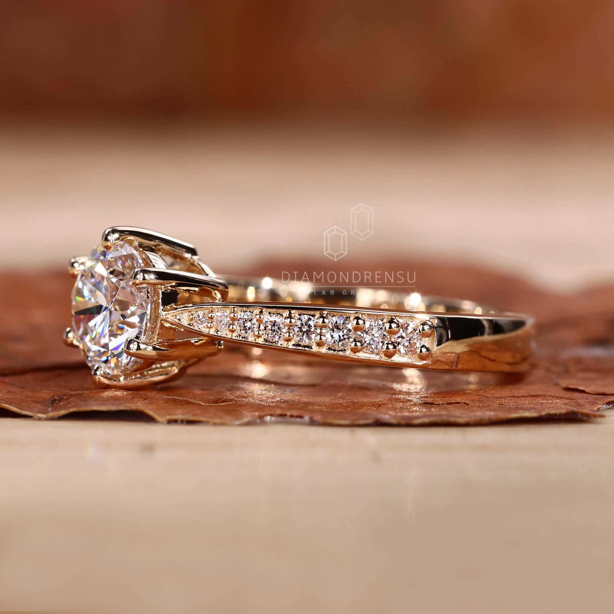 Round ring diamond set in a tapered pave engagement ring for a modern and elegant look.
