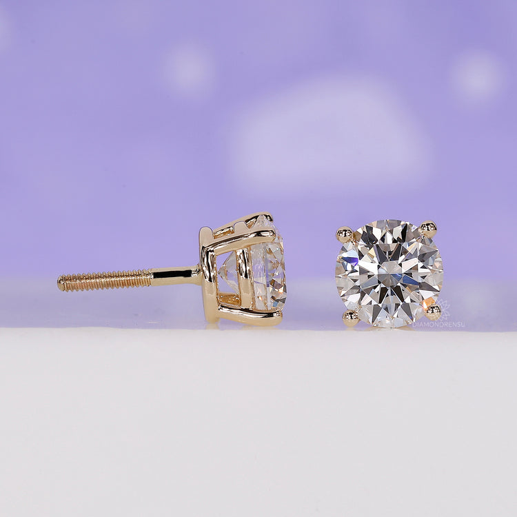 Custom diamond earrings designed as yellow gold round studs.