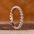 Round rose cut wedding band with a shared prong setting in rose gold.

