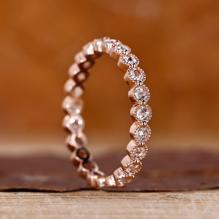 Round rose cut wedding band with a shared prong setting in rose gold.
