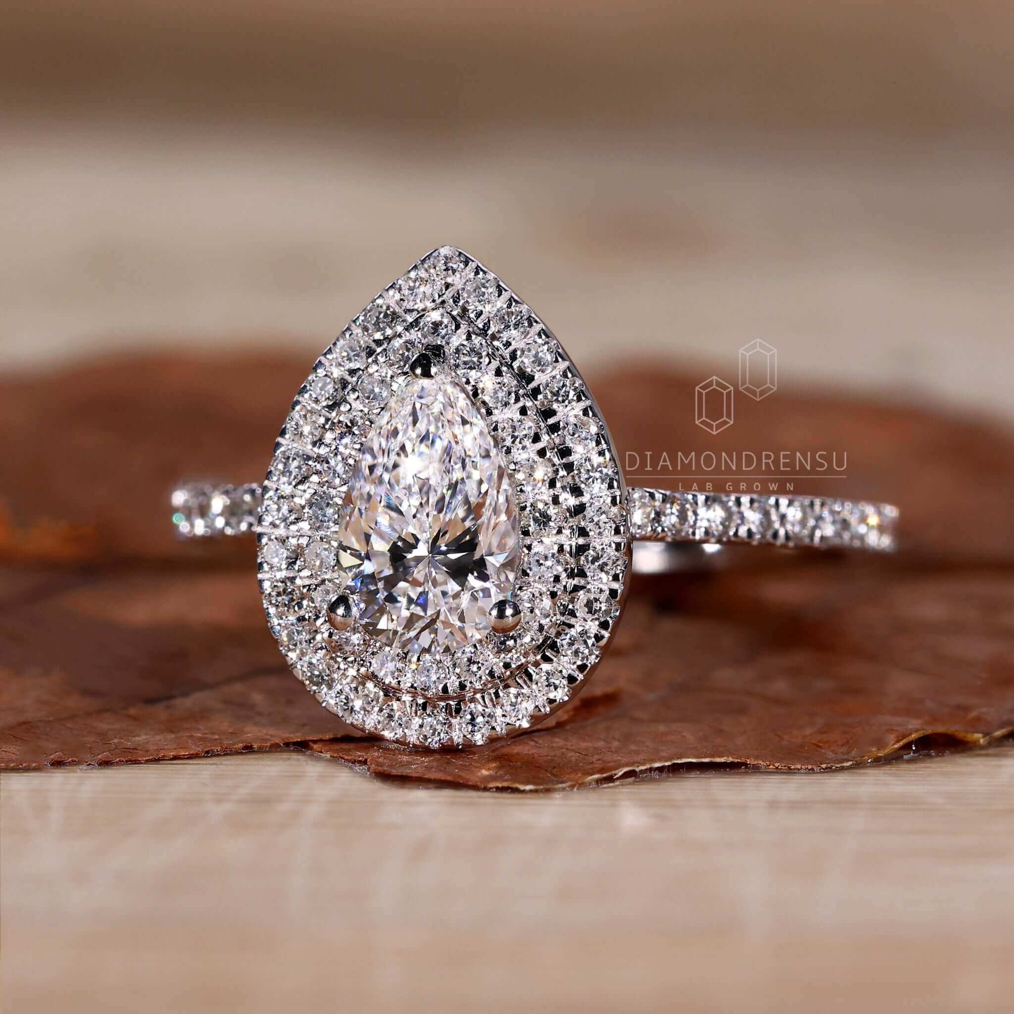 Pear shape diamond ring with pave diamond ring details and an exquisite white gold finish.
