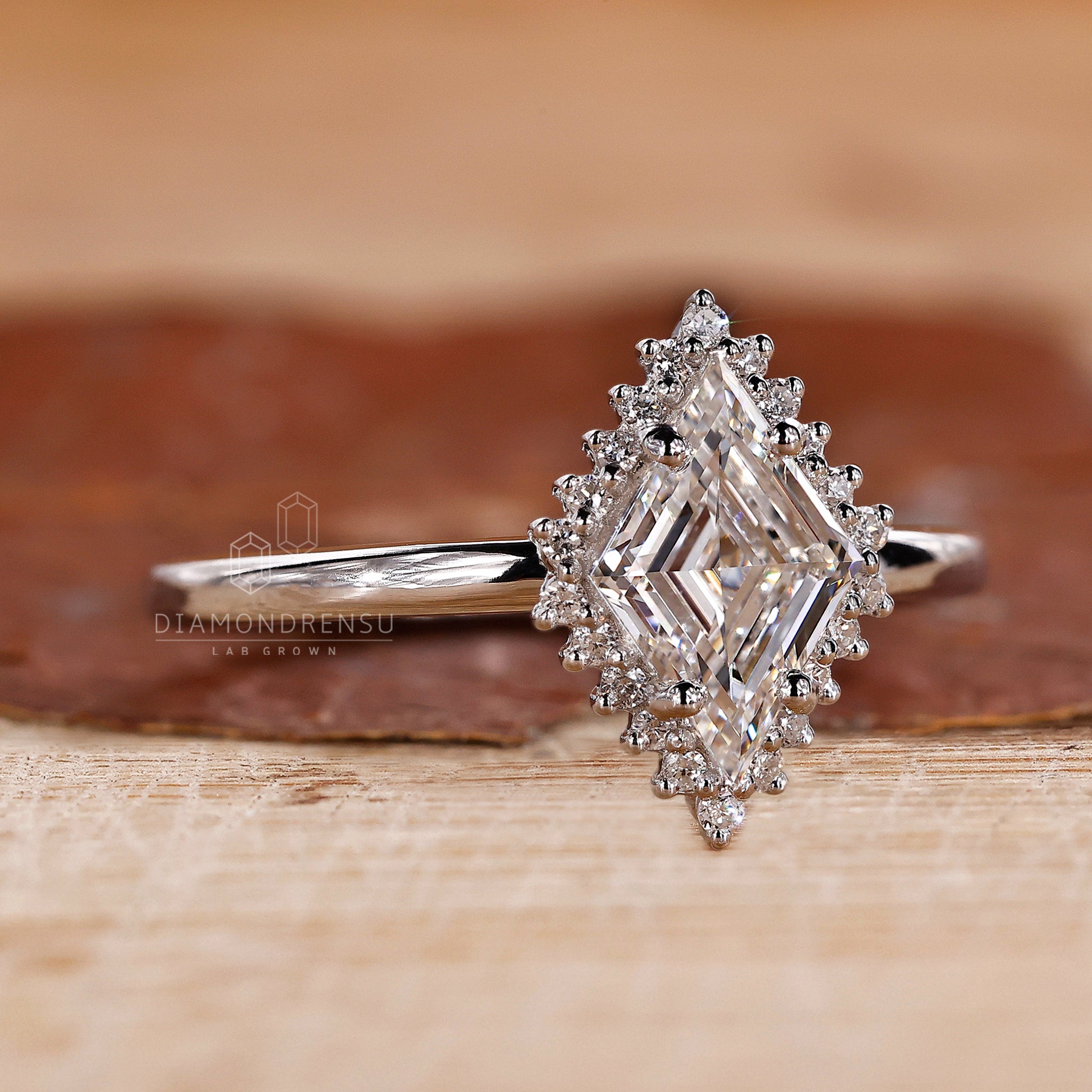 Diamondrensu UK engagement ring with lab diamond and lozenge cut center.
