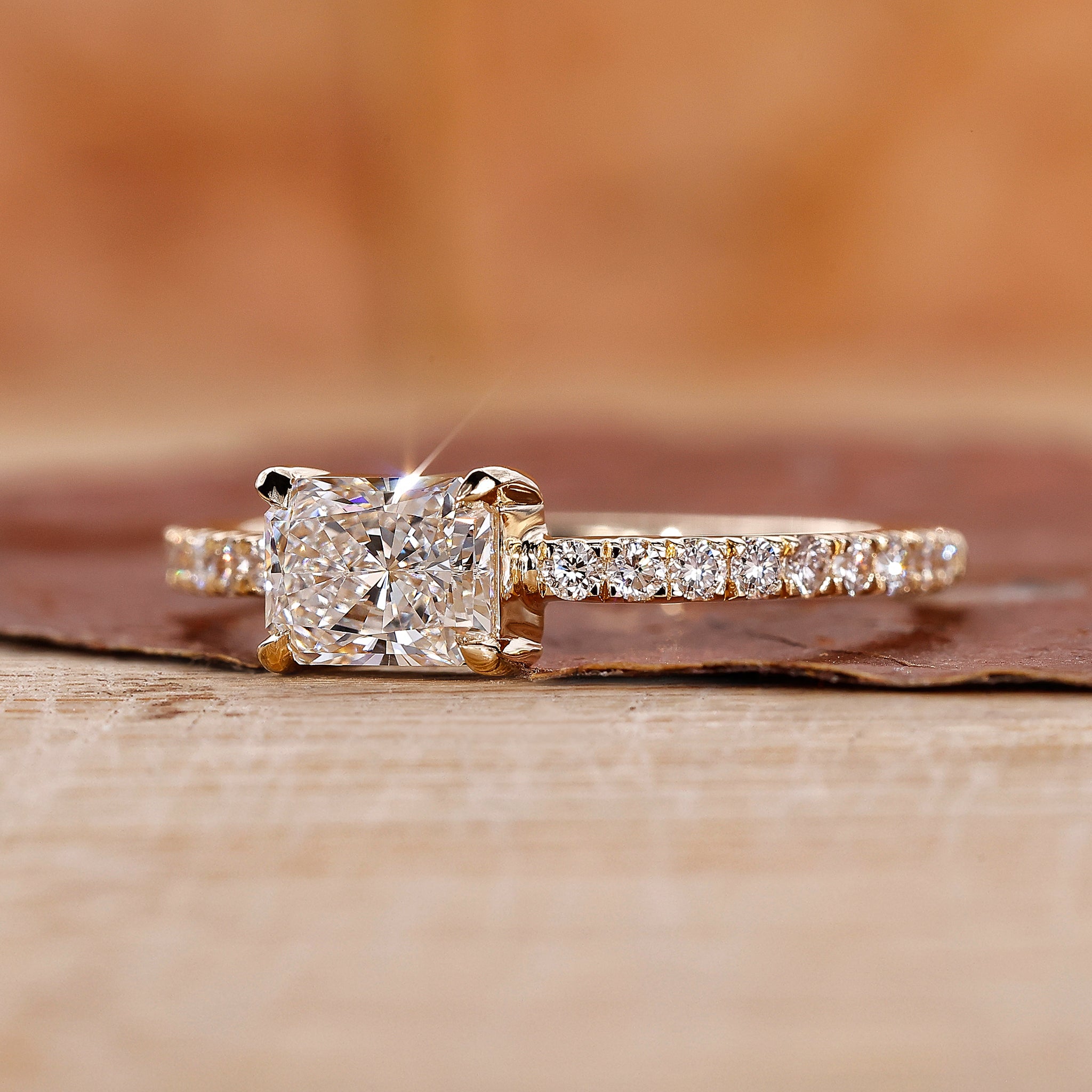Radiant diamond ring with east to west radiant diamond in yellow gold.
