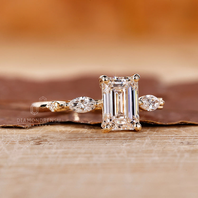 Diamondrensu UK engagement ring with lab diamond emerald center stone.
