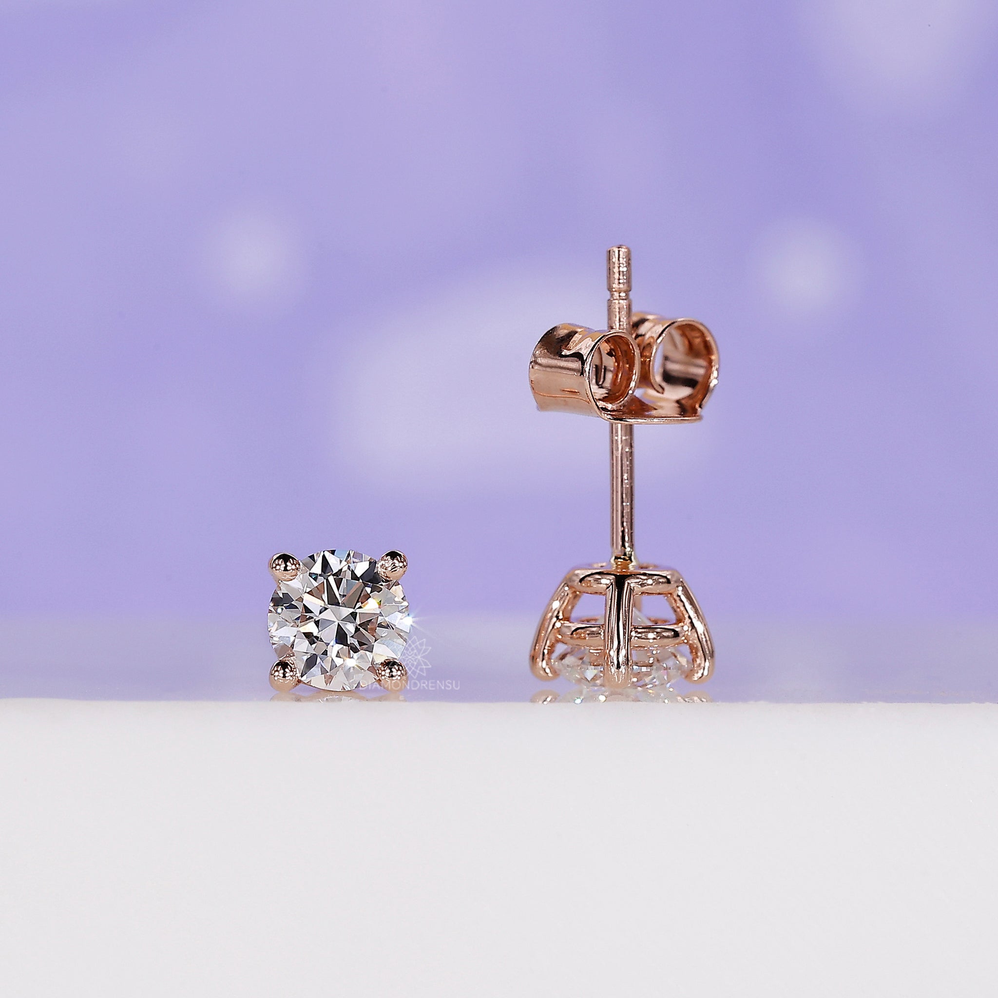Prong setting diamond earrings designed as classic round studs for women.