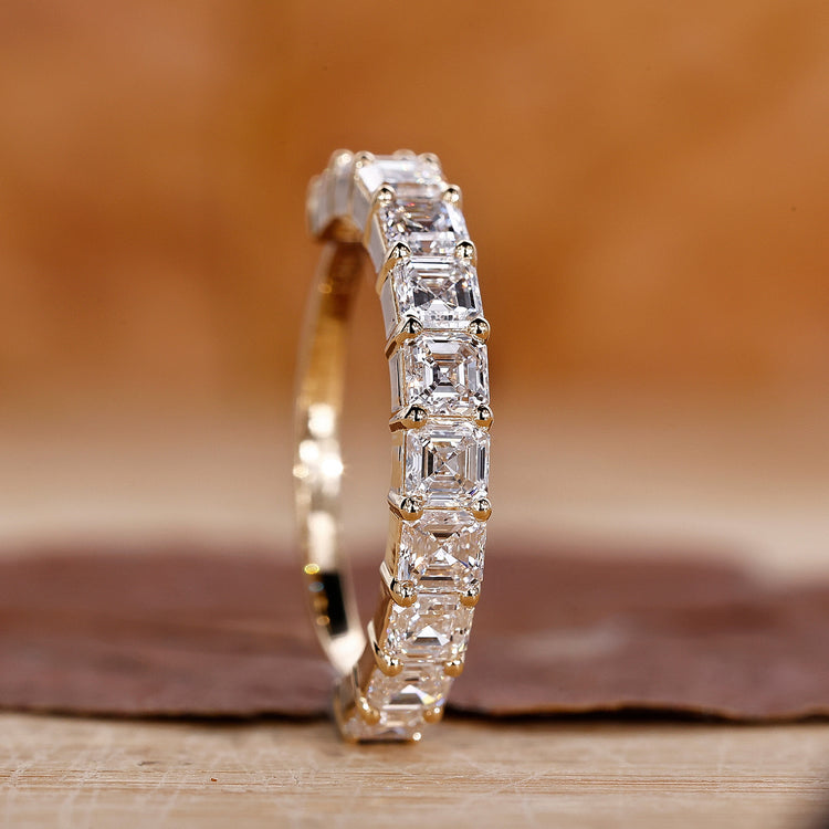 Asscher cut diamond wedding band in yellow gold.

