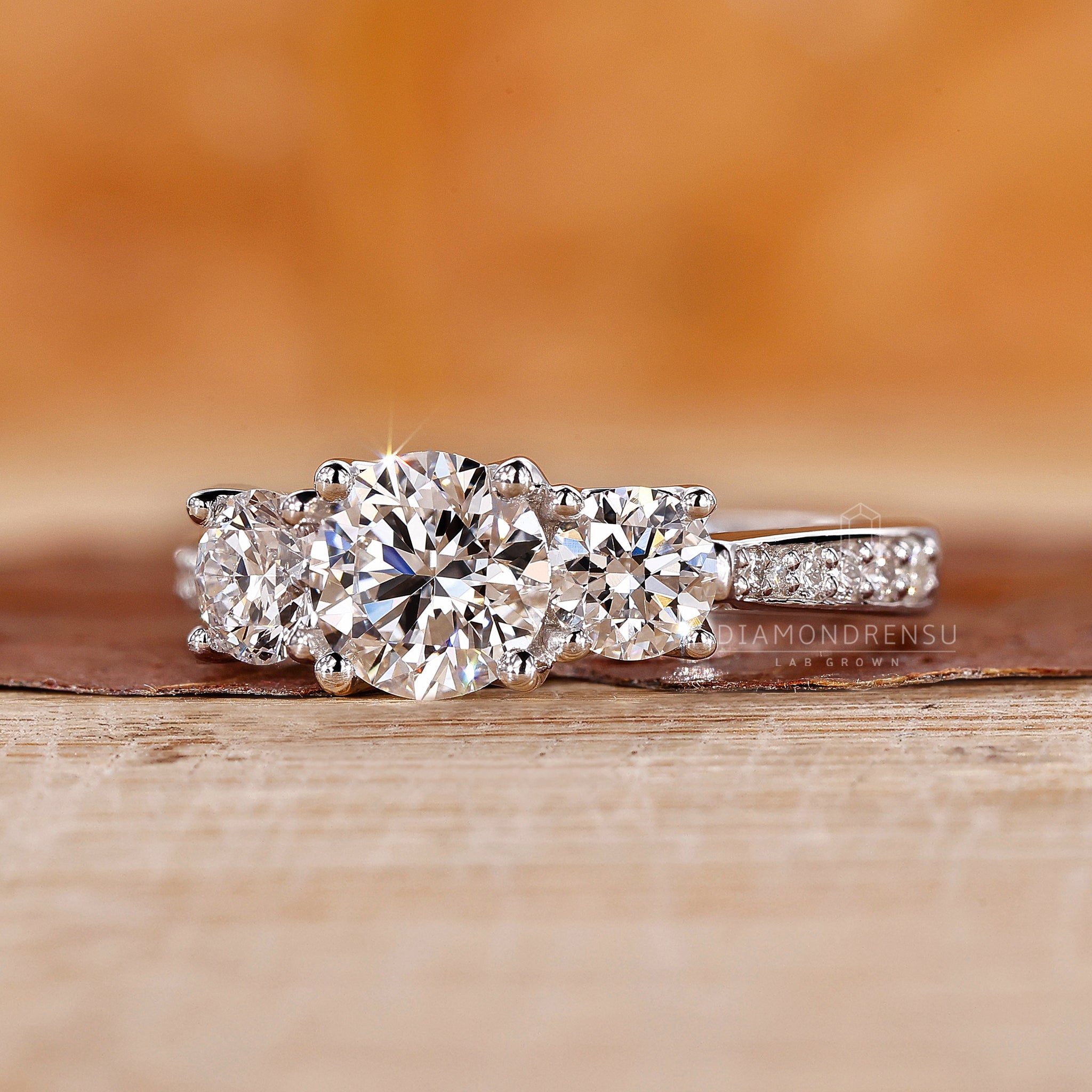 UK engagement ring with prong set three diamond design and lab diamond.
