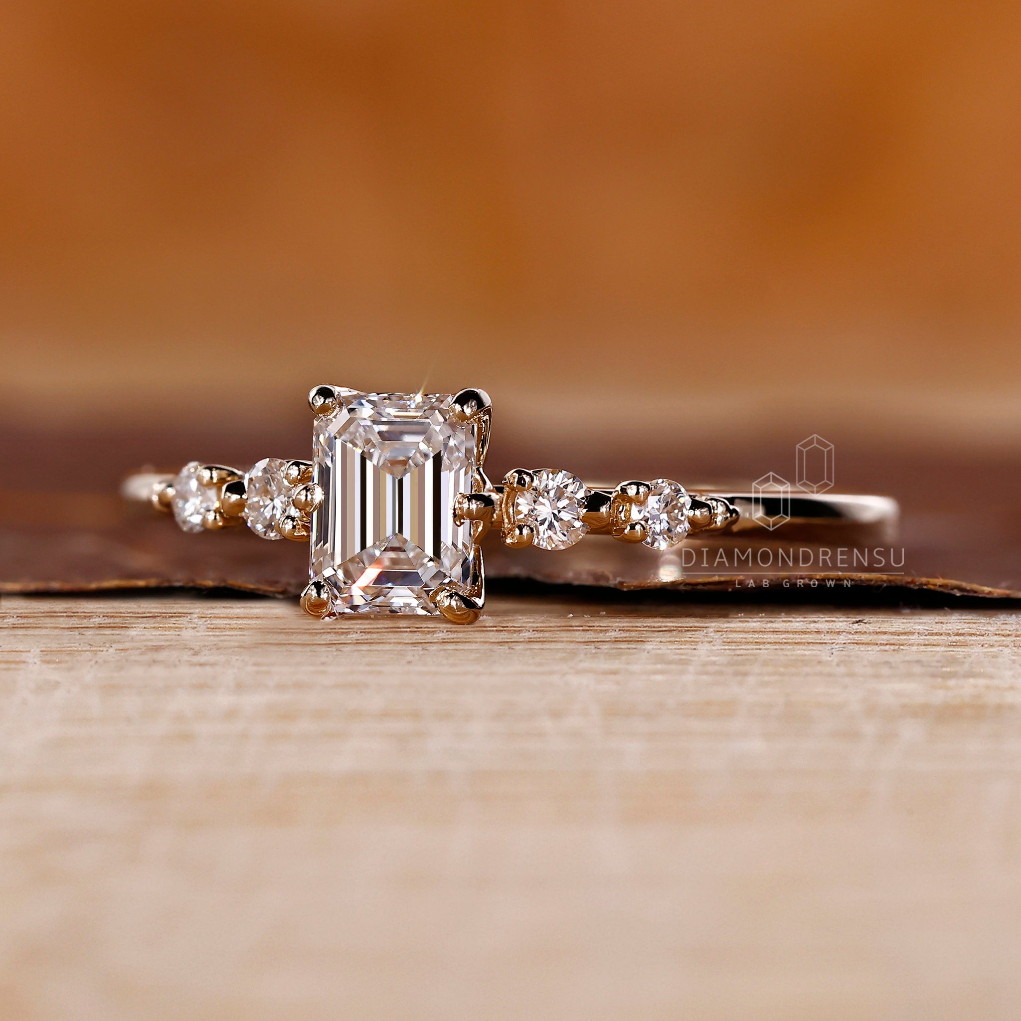 Emerald cut diamond center stone in yellow gold.

