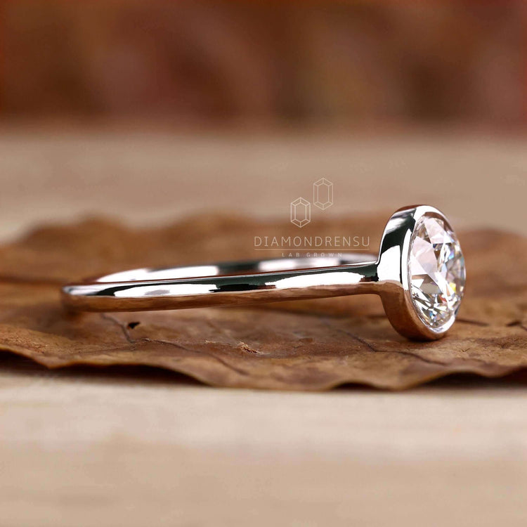 Engagement ring with bezel setting featuring lab-grown diamonds.