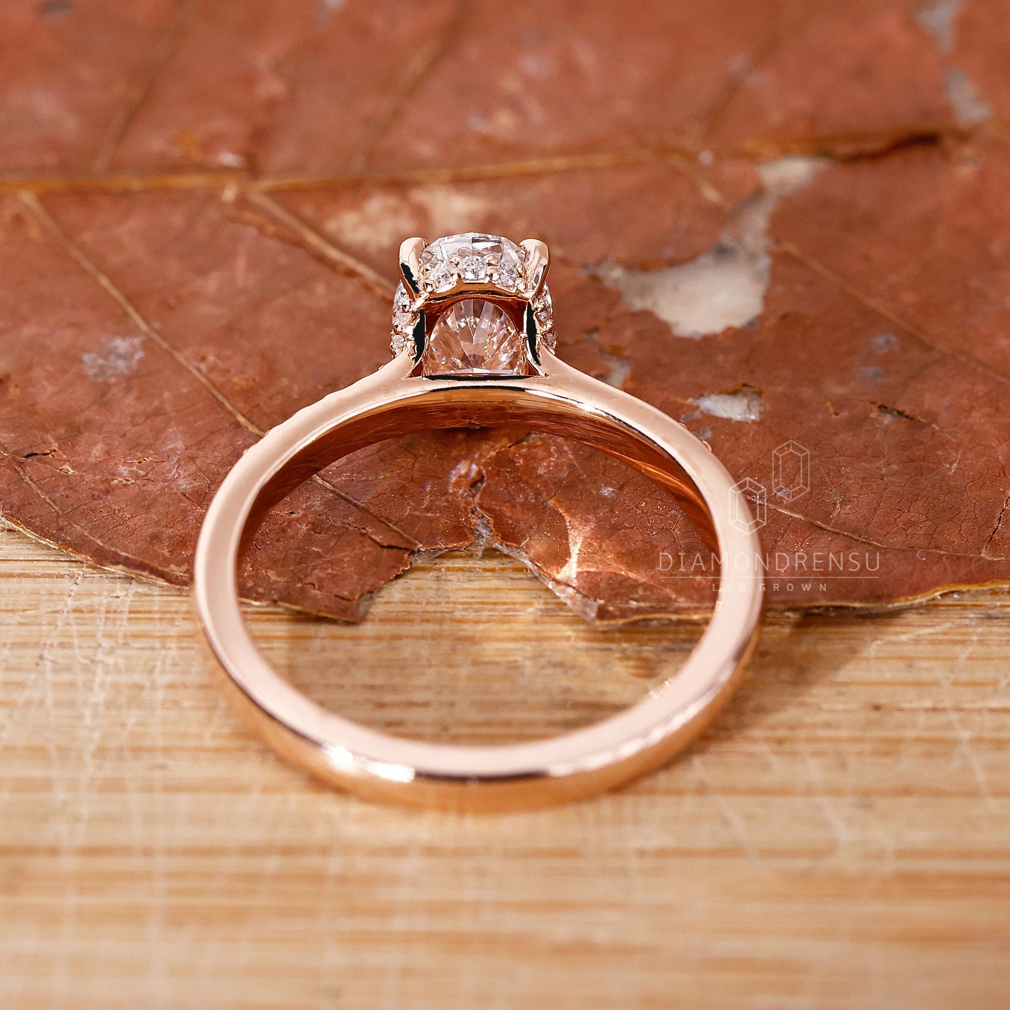 Detailed shot of a lab grown diamond hidden halo engagement ring, highlighting the open gallery and minimal round diamonds.