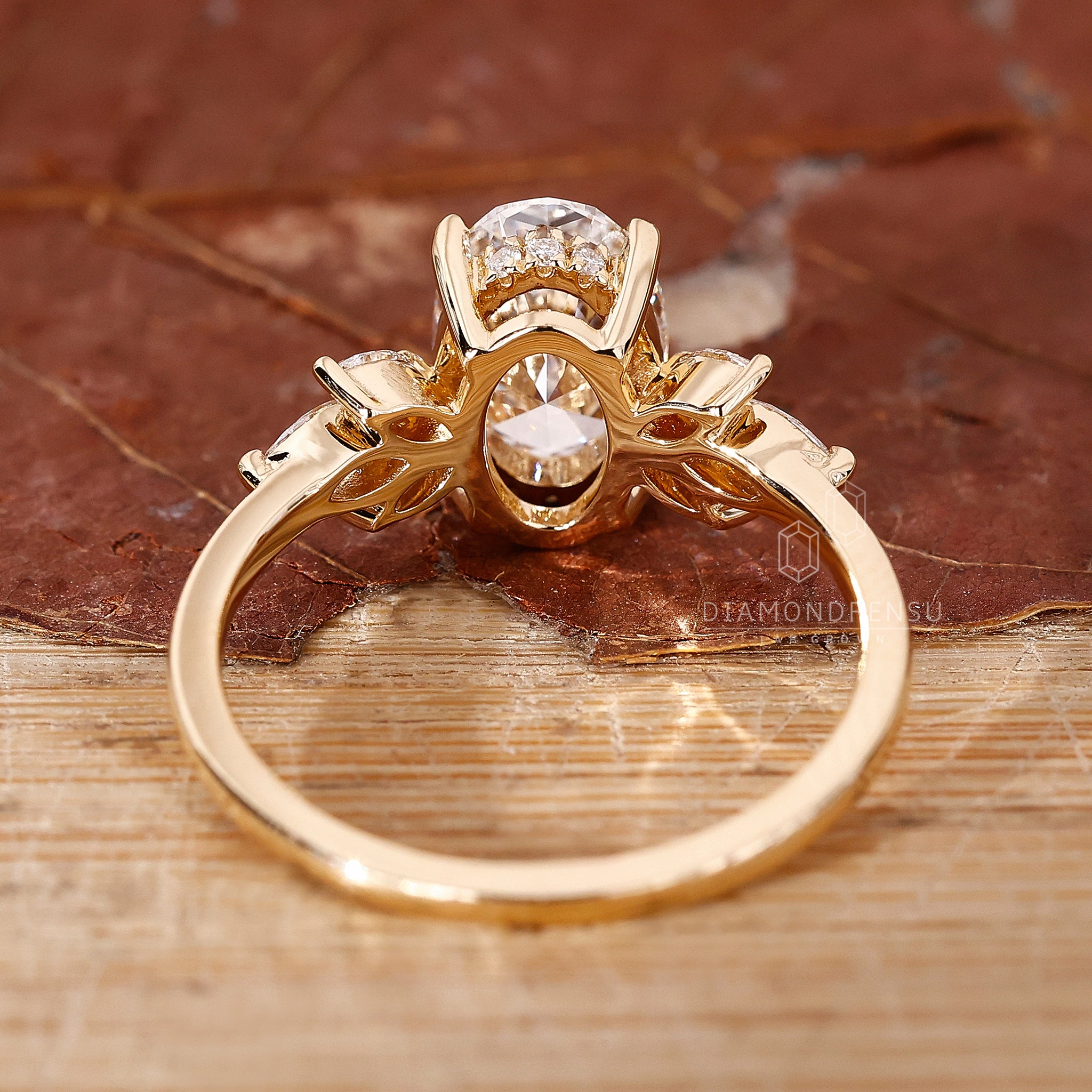 Handmade muse ring with oval diamond centre and side stones.
