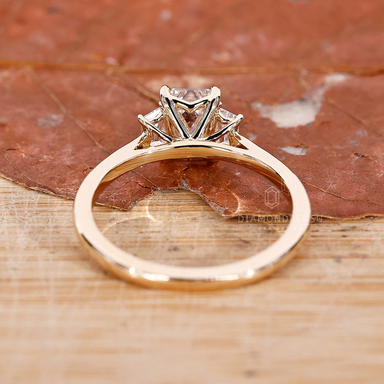 Emerald cut diamond ring with trapezoid accents and lab-grown diamonds.
