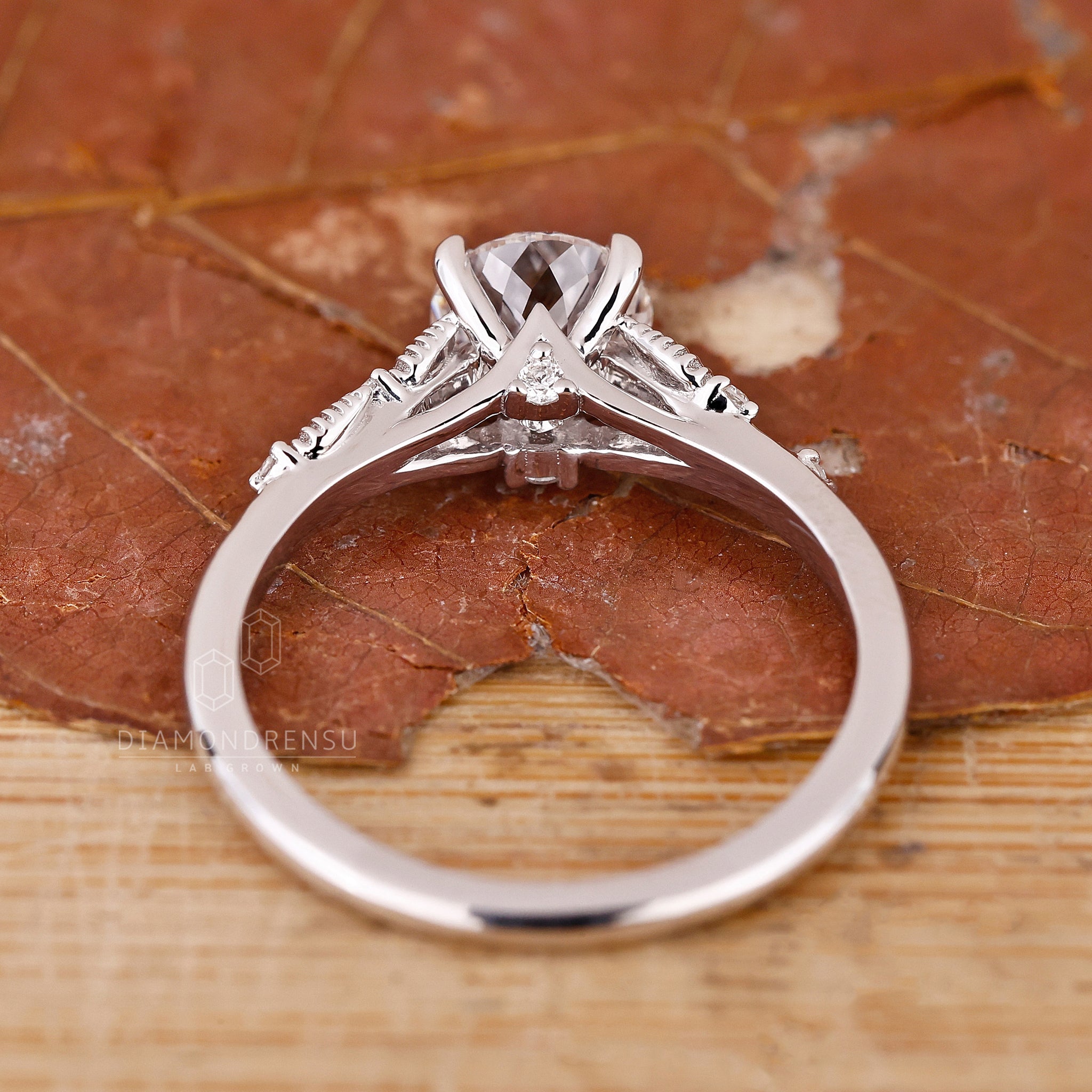 Proposal engagement ring with nature inspired design and round side stones.
