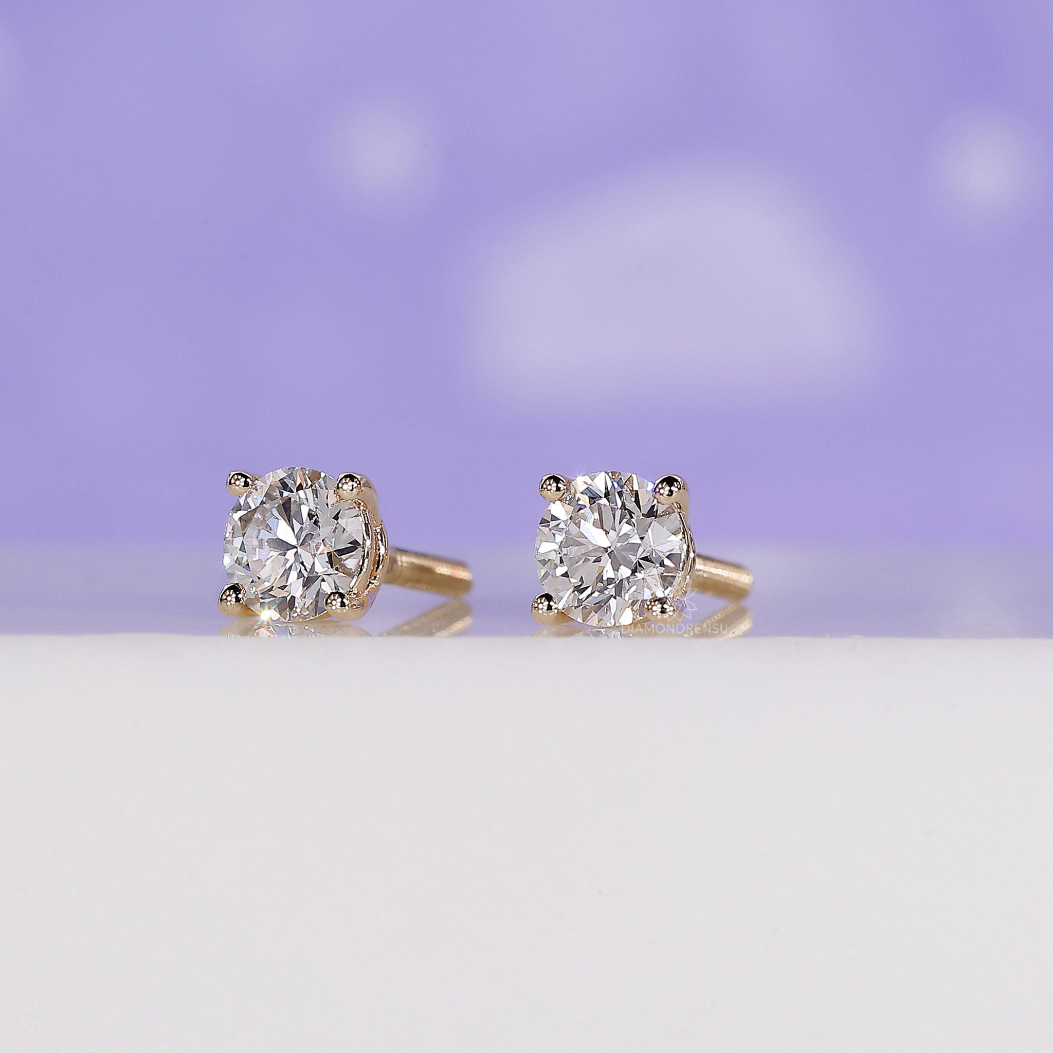 Lab grown diamond earrings in a delicate yellow gold prong setting.