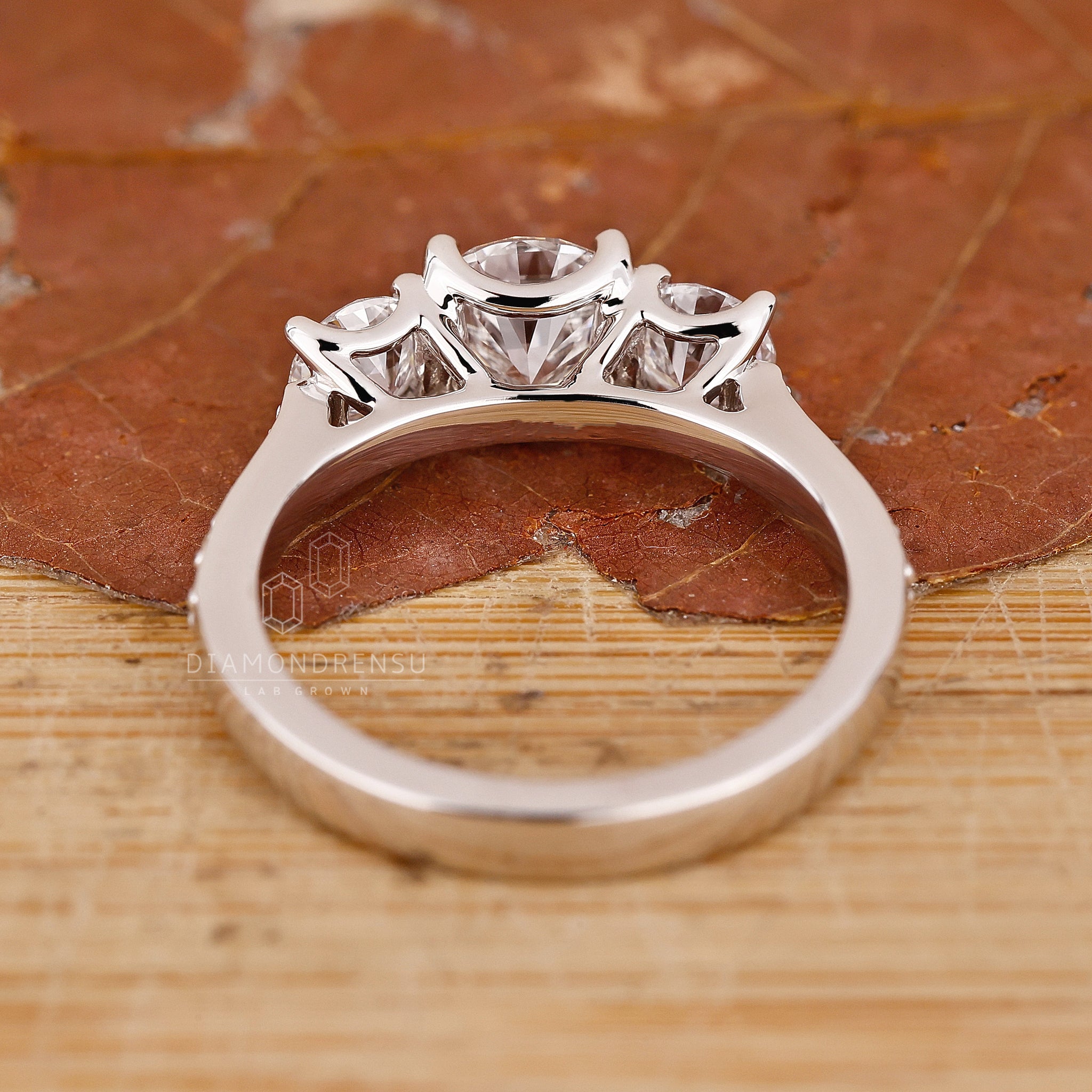 White gold ring with three diamond stones in prong set style.
