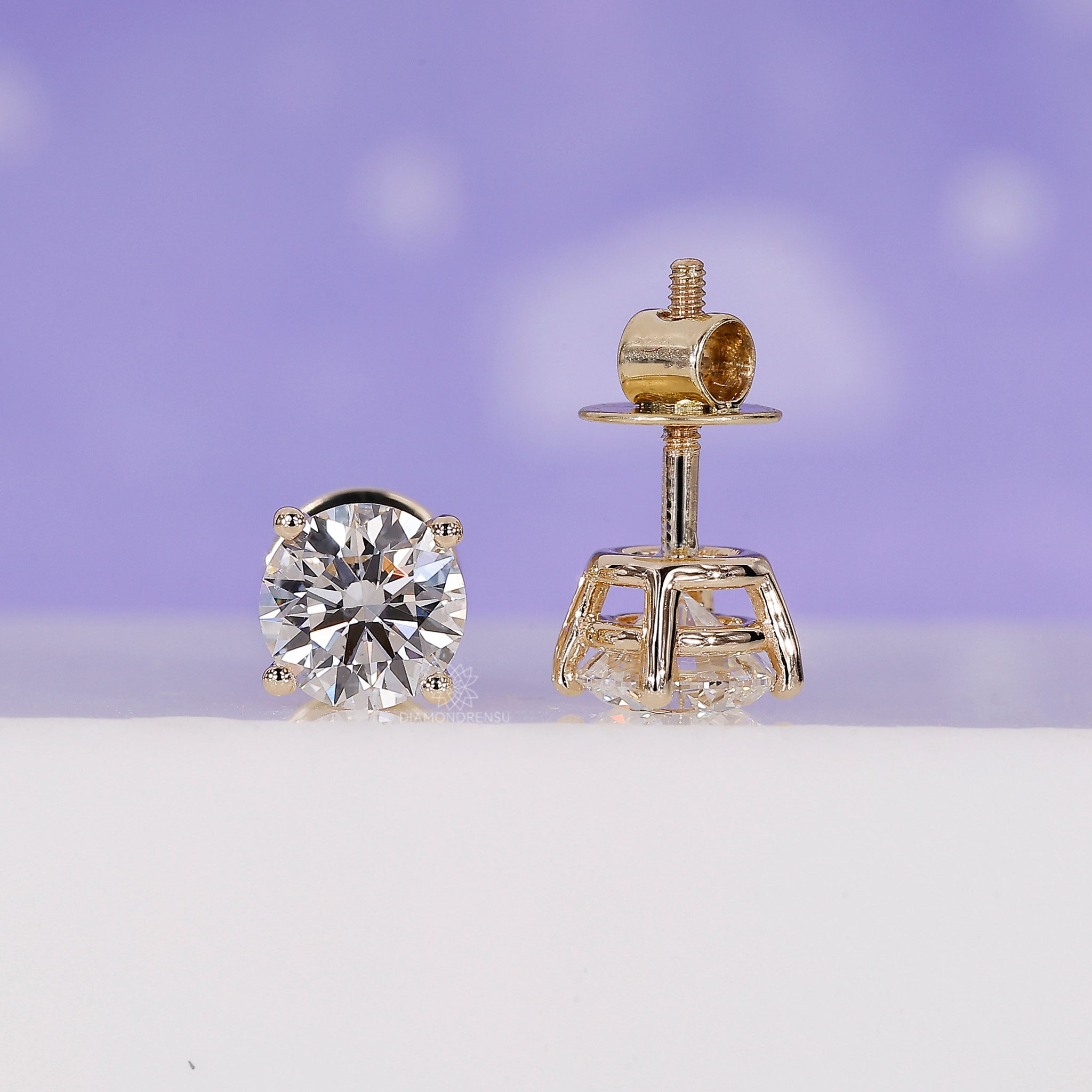 Custom diamond earrings designed as gold round studs.