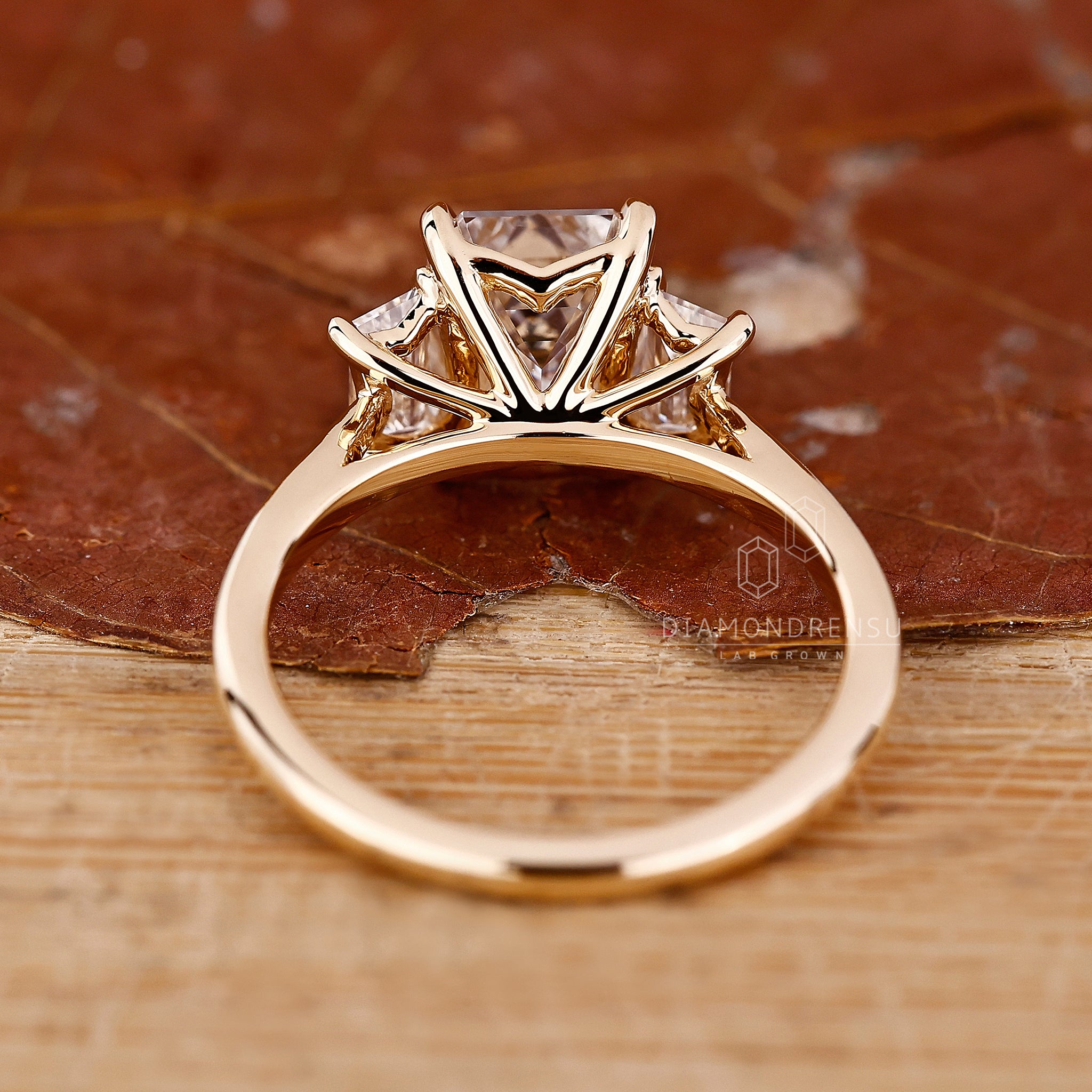 Unique engagement ring includes emerald and trapezoid diamonds.
