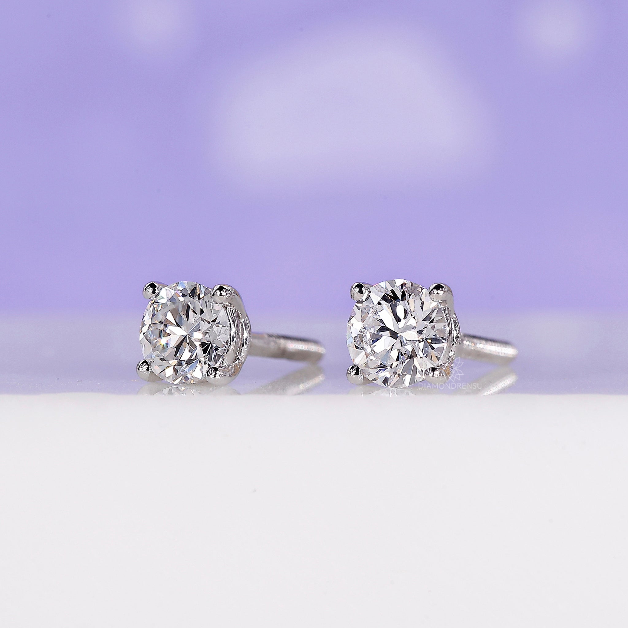 Round diamond earrings with prong setting and a handmade finish.