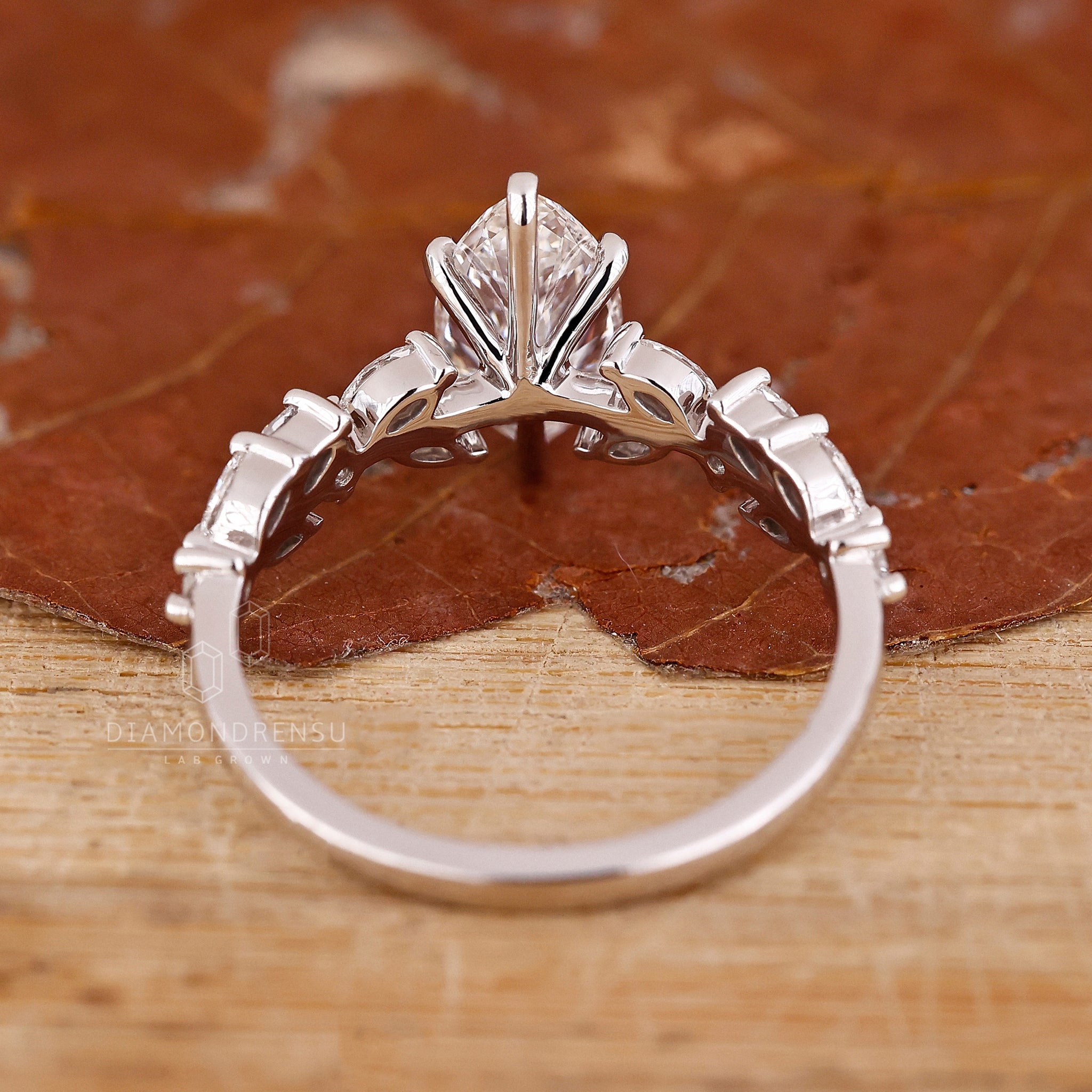 UK engagement ring in white gold with lab marquise center diamond.
