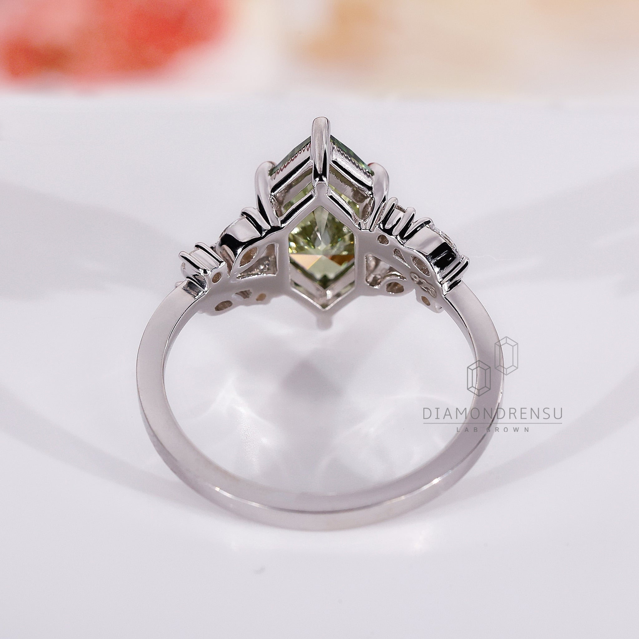 Green diamond ring with marquise and round side stones.