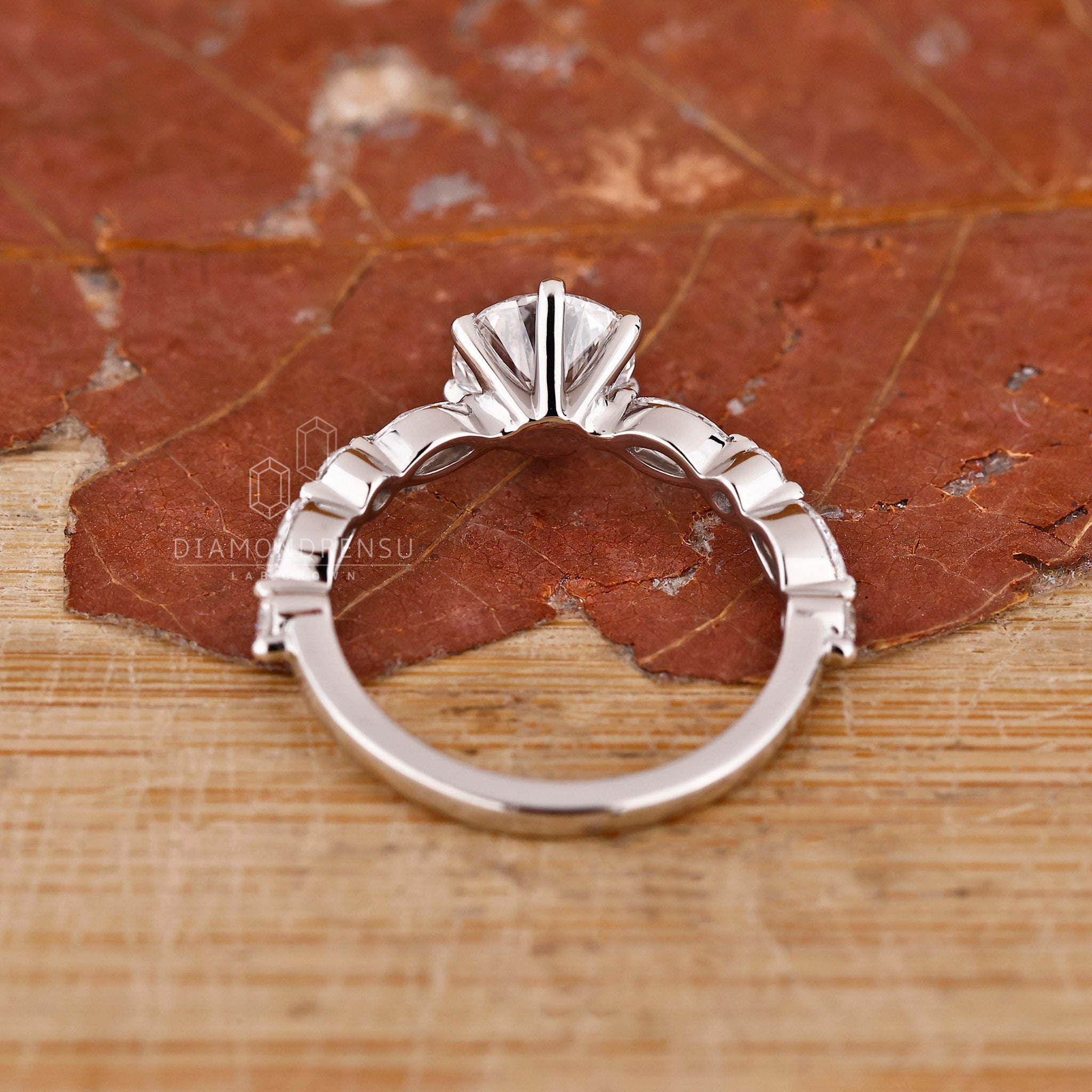 Handmade jewellery ring featuring round and marquise side stones in white gold.
