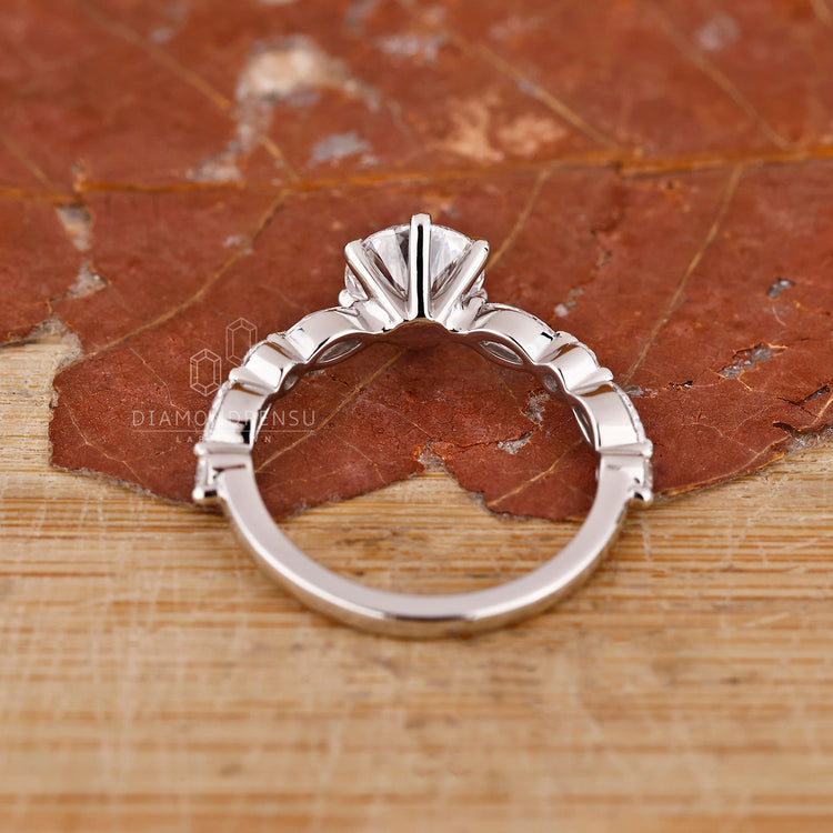 Handmade jewellery ring featuring round and marquise side stones in white gold.

