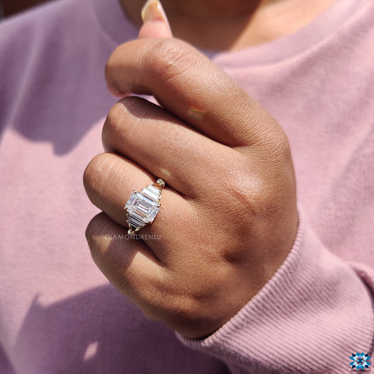 Split shank engagement ring with emerald cut center stone.
