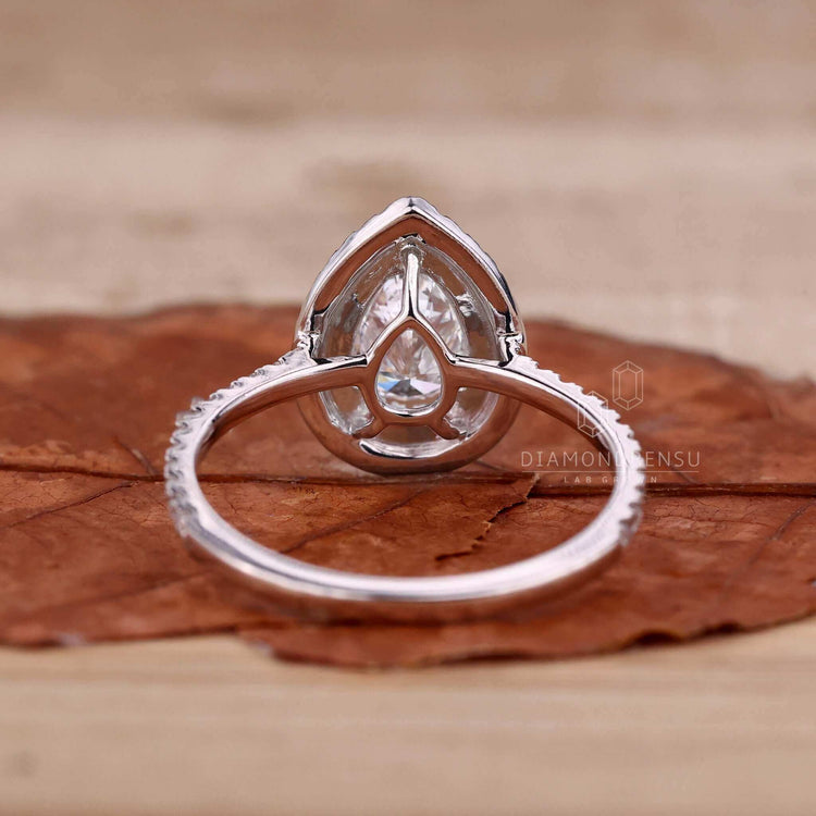 Pear cut diamond engagement ring featuring a claw prong ring and pave ring diamond accents.
