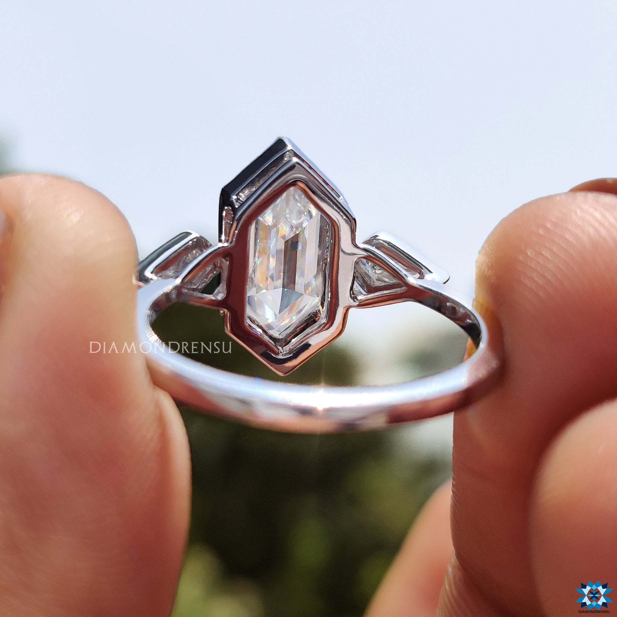 UK engagement ring with bezel-set hexagon and kite moissanite stones.
