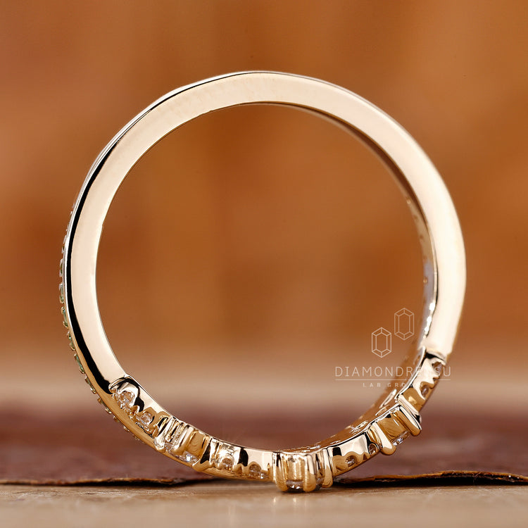 Wedding band UK with green gemstones.
