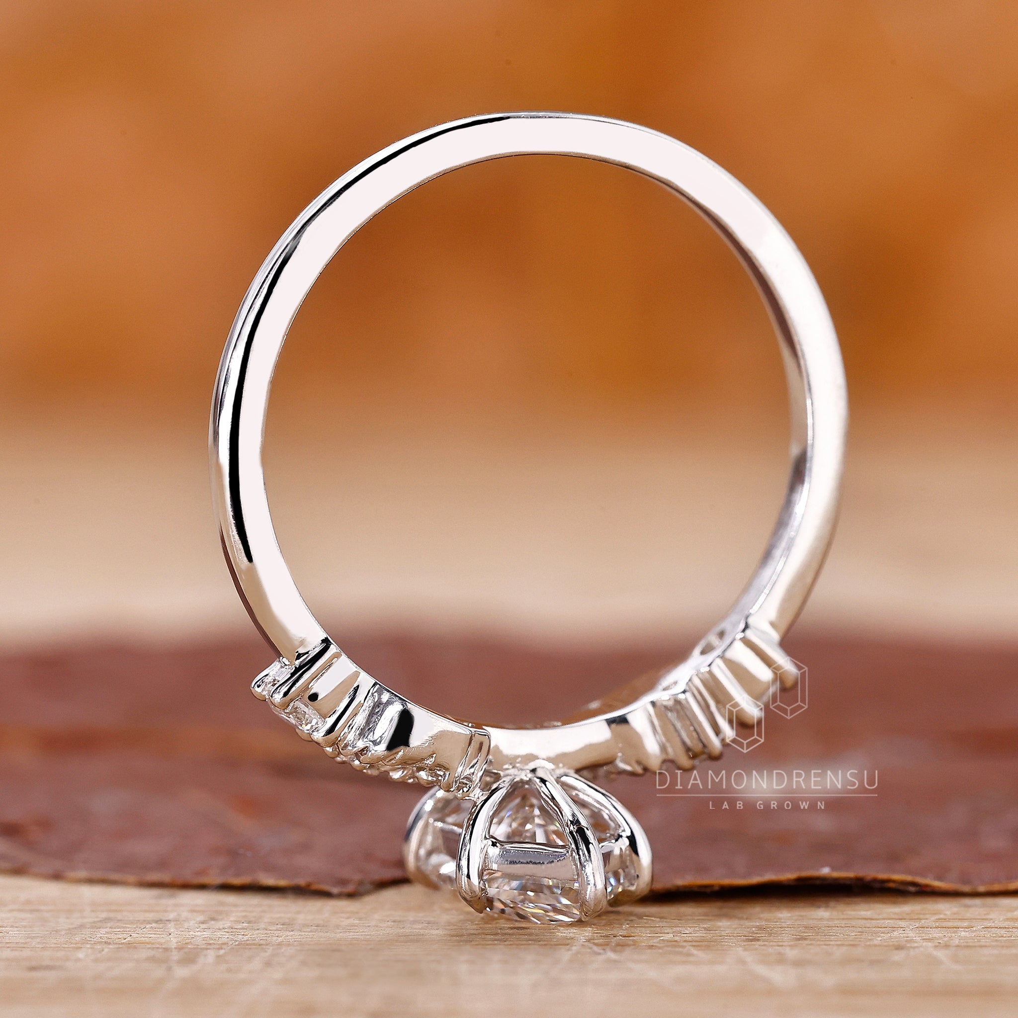 Round side stone ring with custom design and lab grown diamonds.

