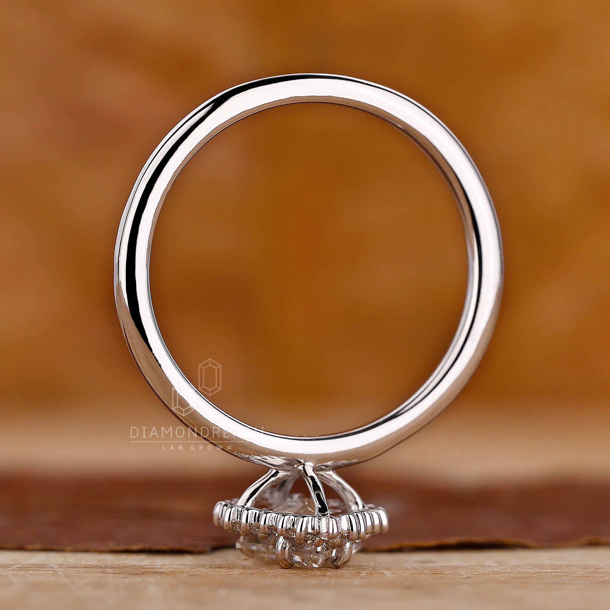 Custom engagement ring with lozenge cut diamond and prong set band.
