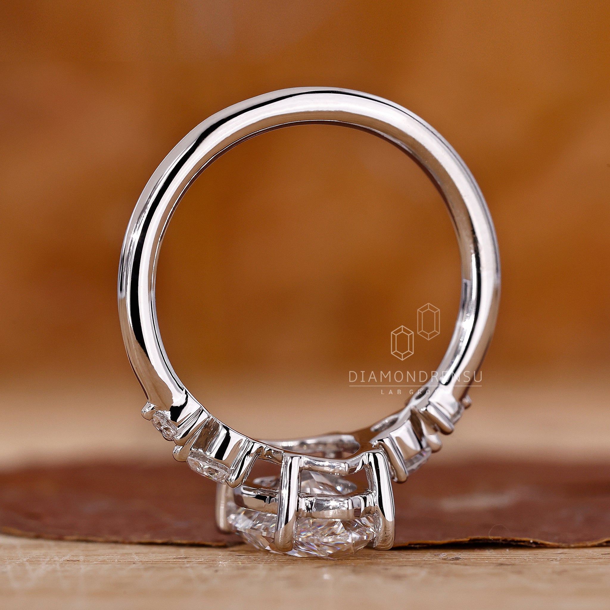 White gold ring with prong setting and round side stones.
