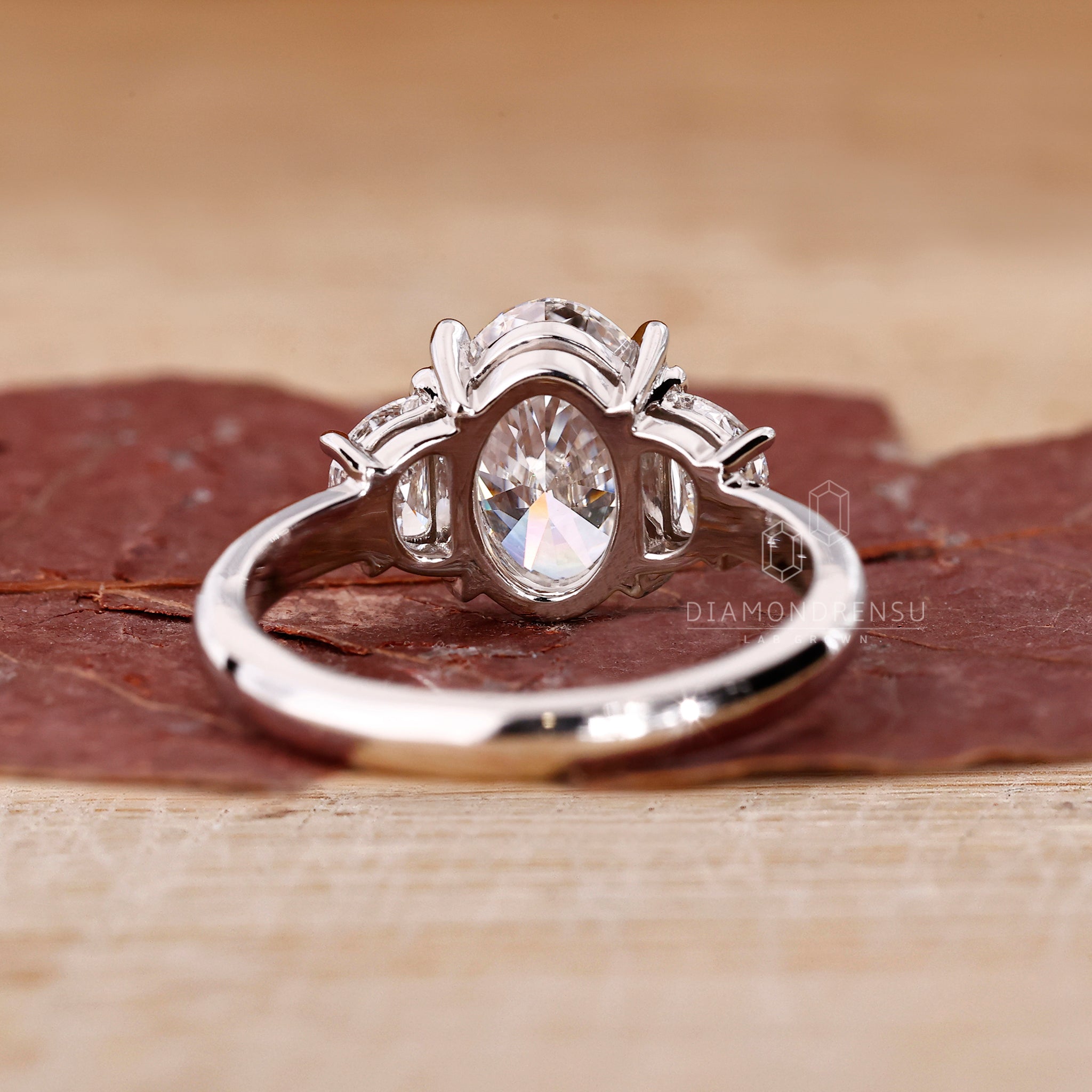 Oval diamond engagement ring with handcrafted half moon accents.
