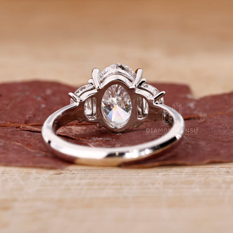 Oval diamond engagement ring with handcrafted half moon accents.
