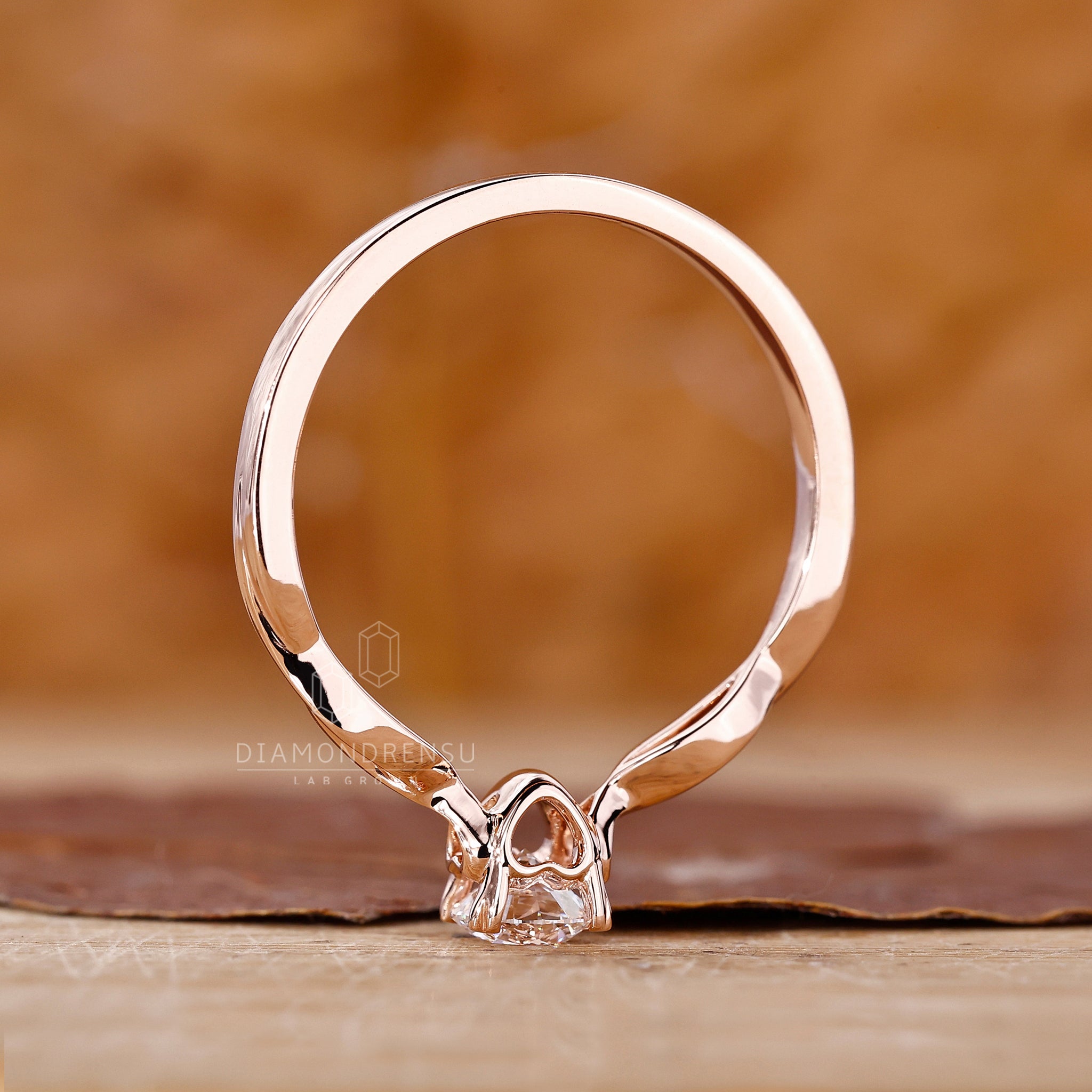Round diamond solitaire engagement ring in rose gold and custom setting.
