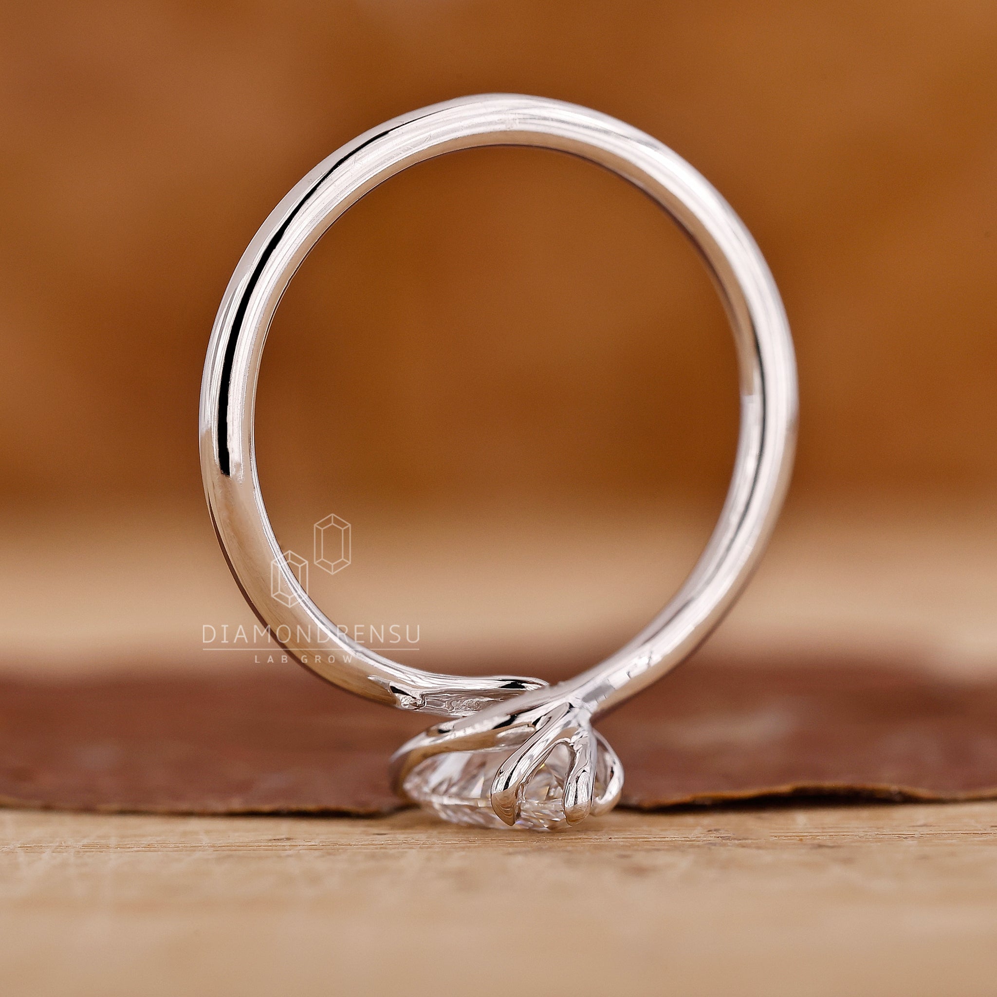 Custom white gold ring with pear shaped centre stone.
