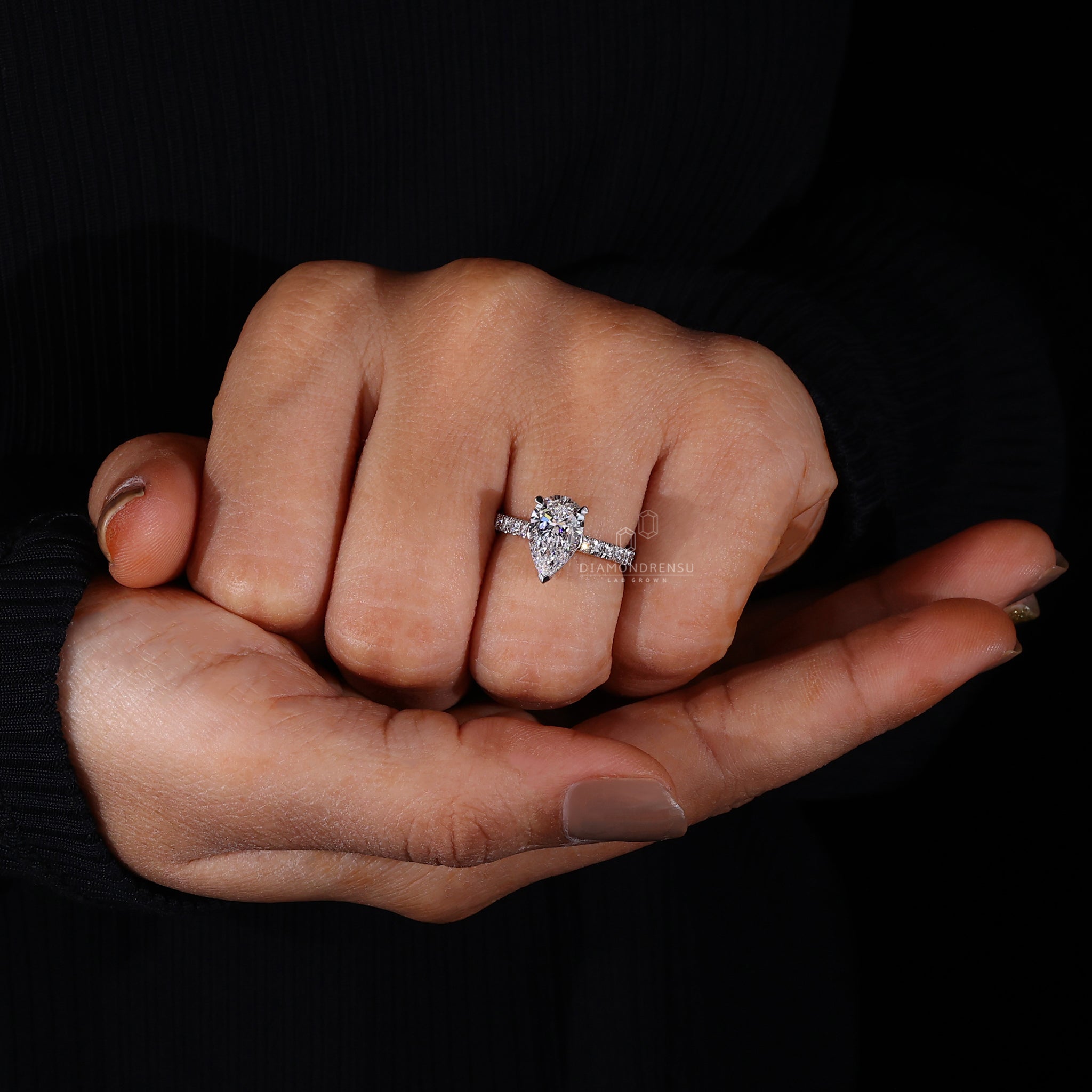 Elegant pear shaped diamond engagement ring on a model's hand