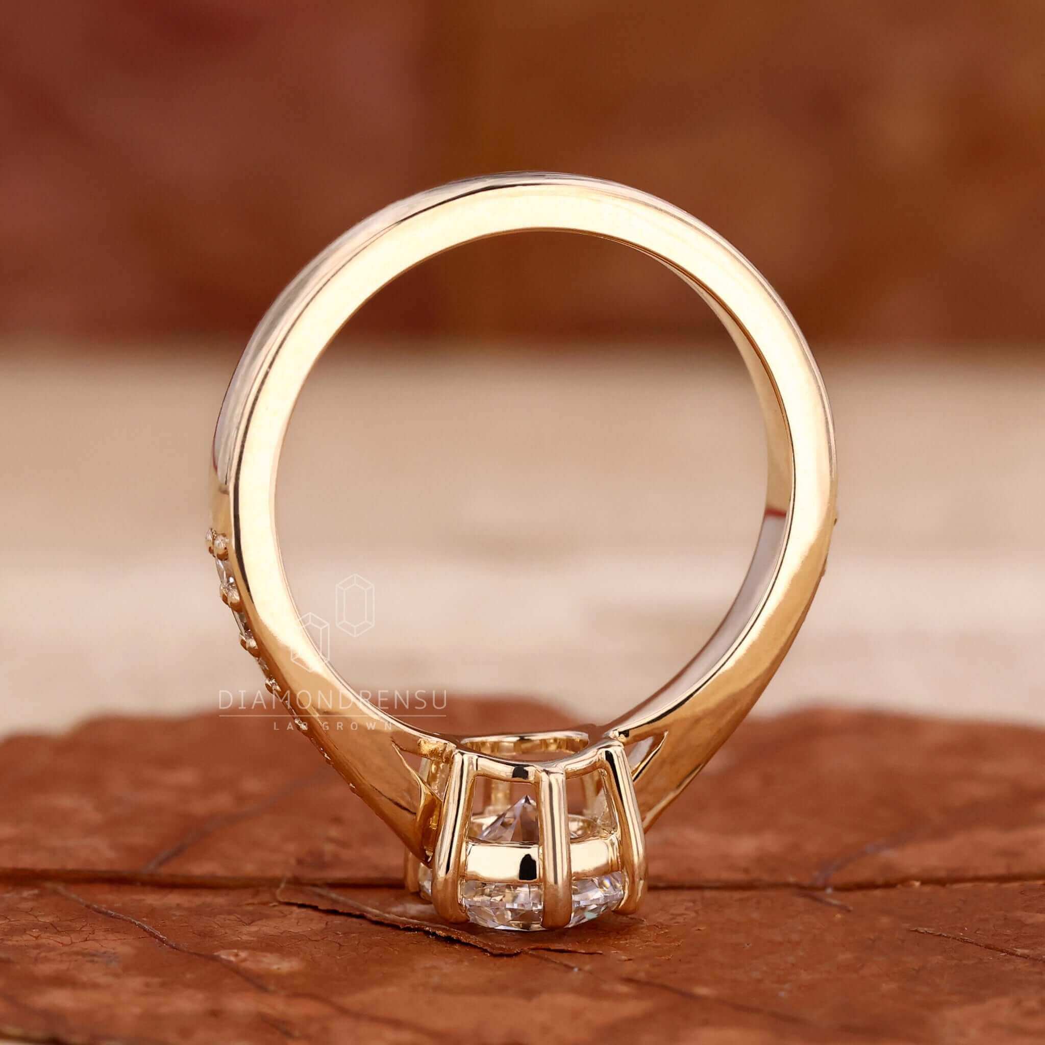 Diamond engagement ring in yellow gold with a tapered pave ring design for classic appeal.
