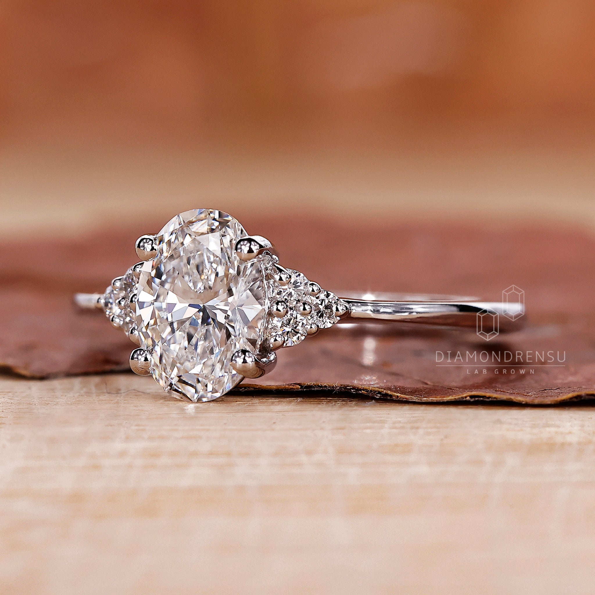 White gold ring with oval cut engagement diamond and prong setting.
