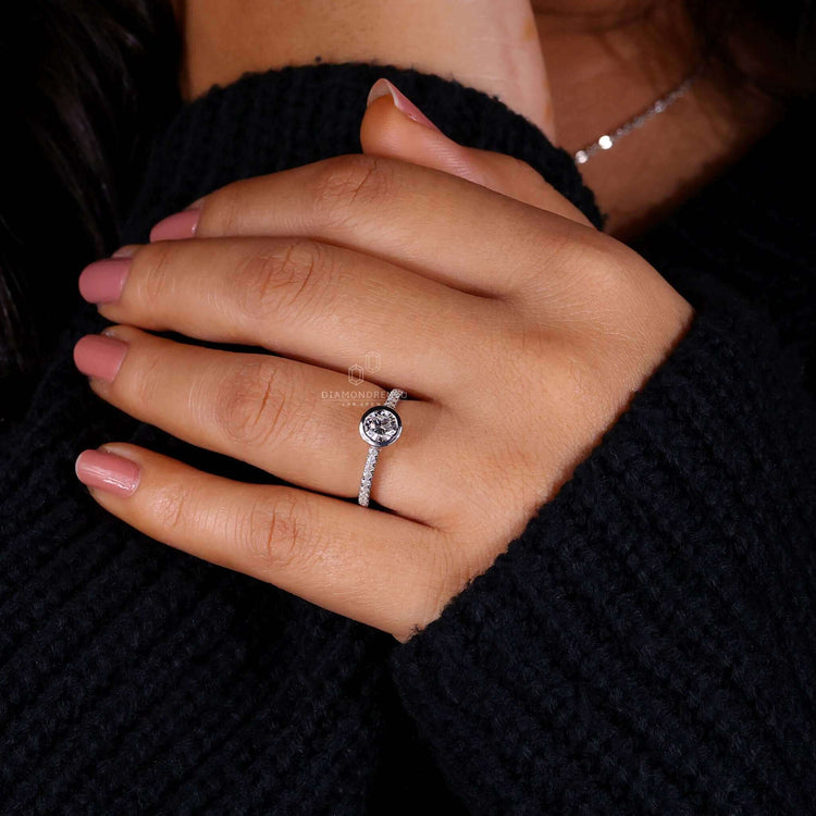 Round diamond ring in a pave setting with a bezel set engagement ring design, crafted for elegance and brilliance.
