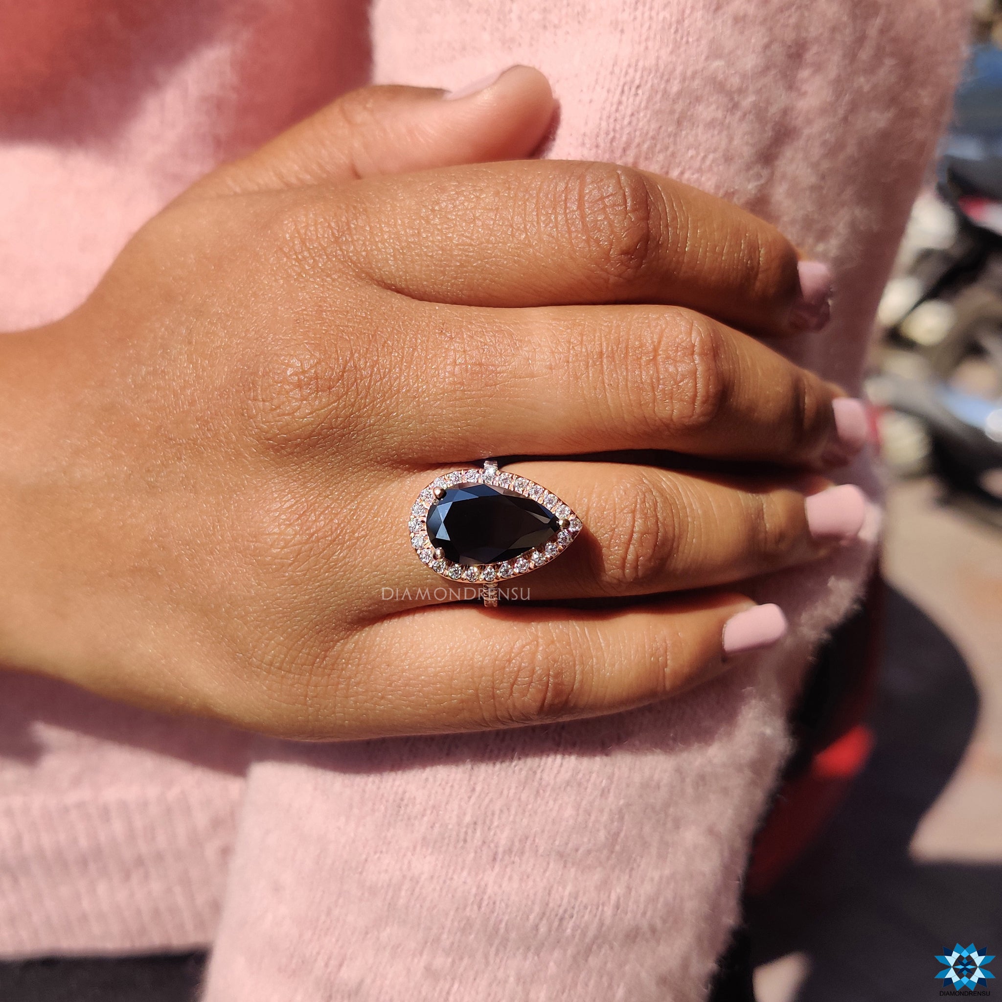 UK engagement ring with black moissanite and round cut halo in rose gold.
