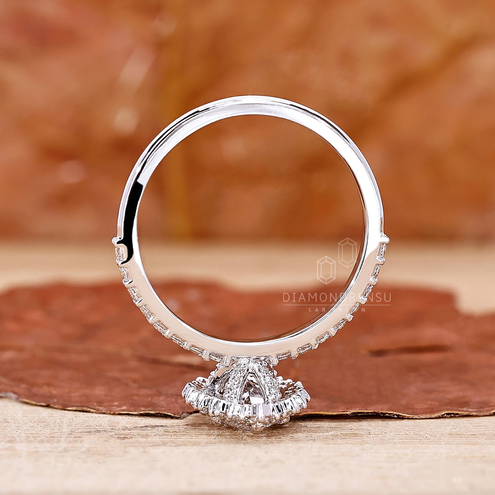 Diamondrensu UK engagement ring with a round cut halo and pave accents.
