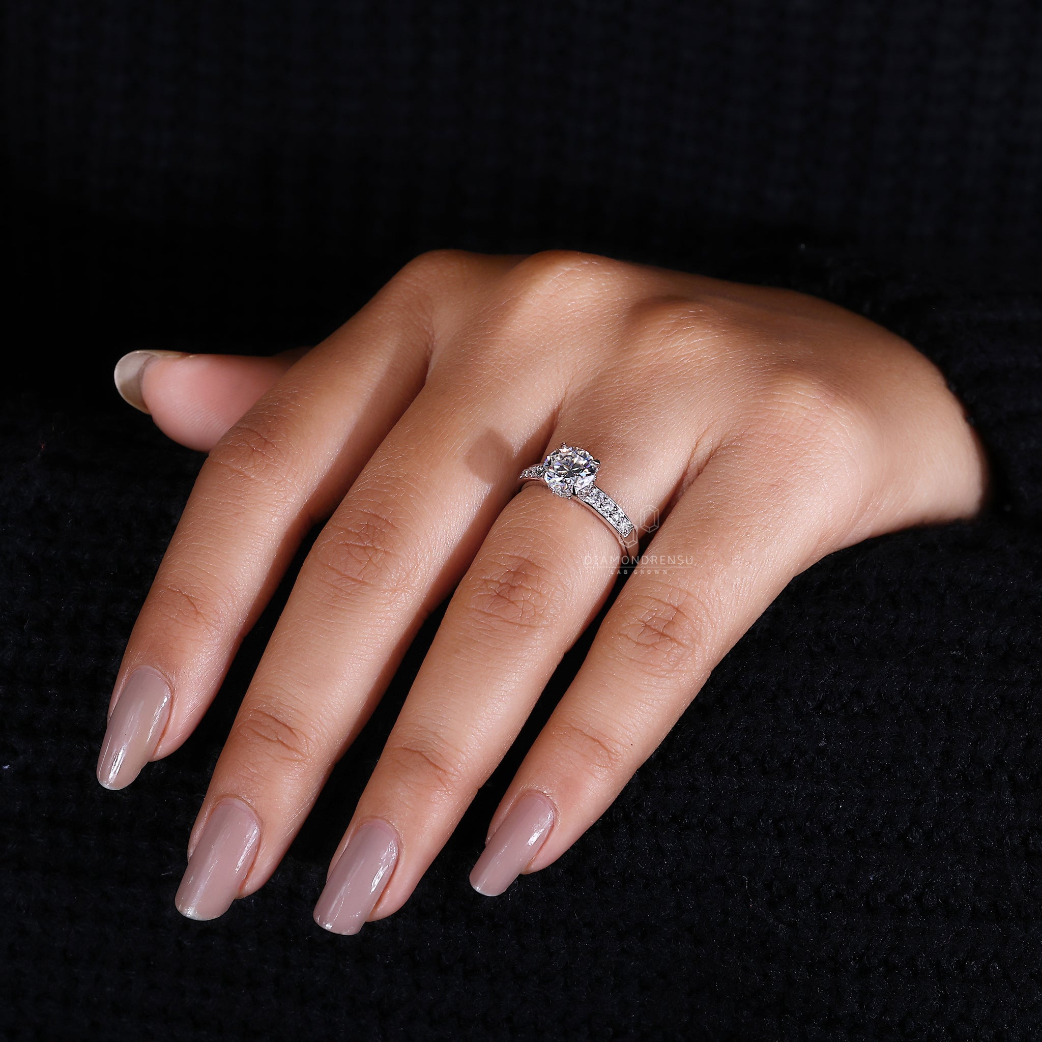 Round cut side stones on white gold diamond ring.
